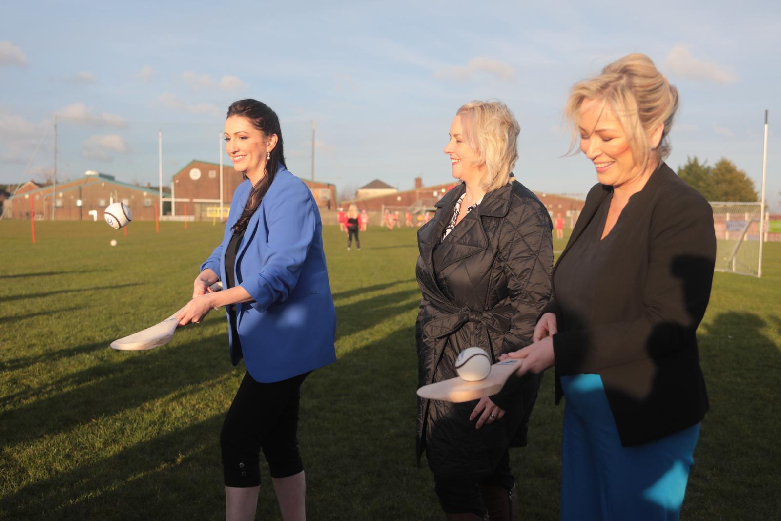 TOGETHER: First Minister Michelle O\'Neill and deputy First Minister Emma Littte-Pengelly show off their camogie skills at St Paul\'s GAC on the Shaws Road on Wednesday night not far from Casement Park