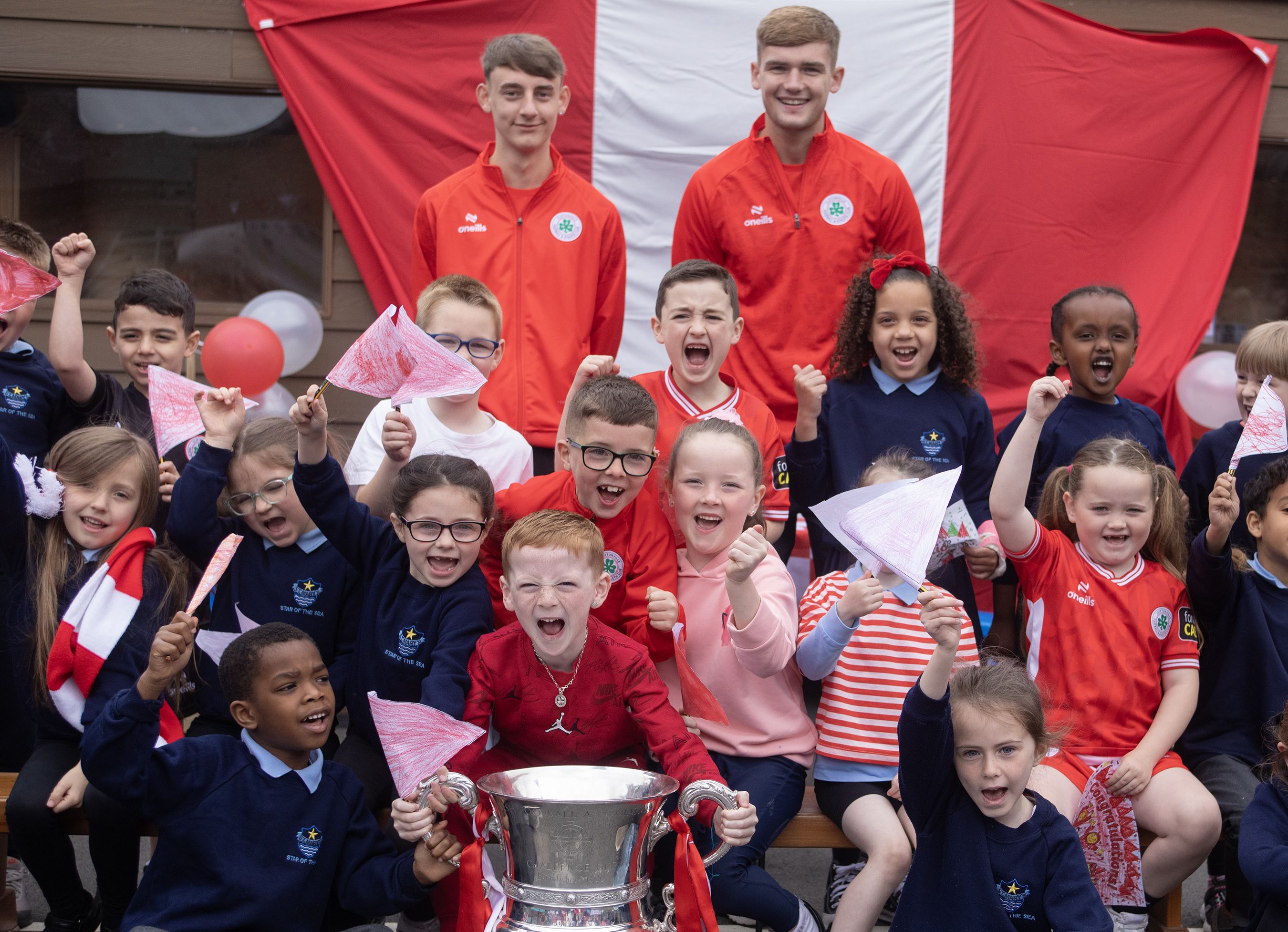 YOU REDS:  Cliftonville players Odhrán Casey and Caoimhin Hawthorne with pupils at St Mary\'s Star of the Sea PS