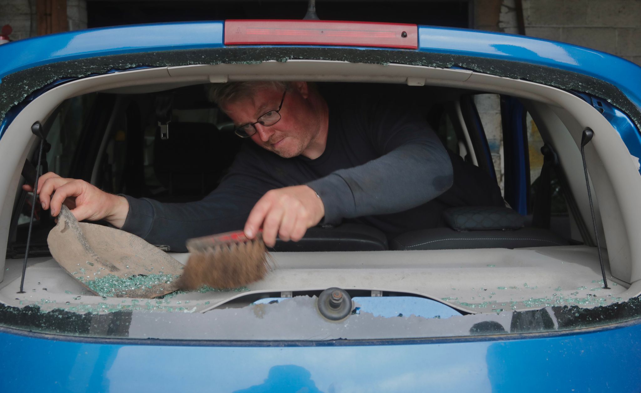 VANDALISM: Business owner Kevin McAtee clears the shattered glass