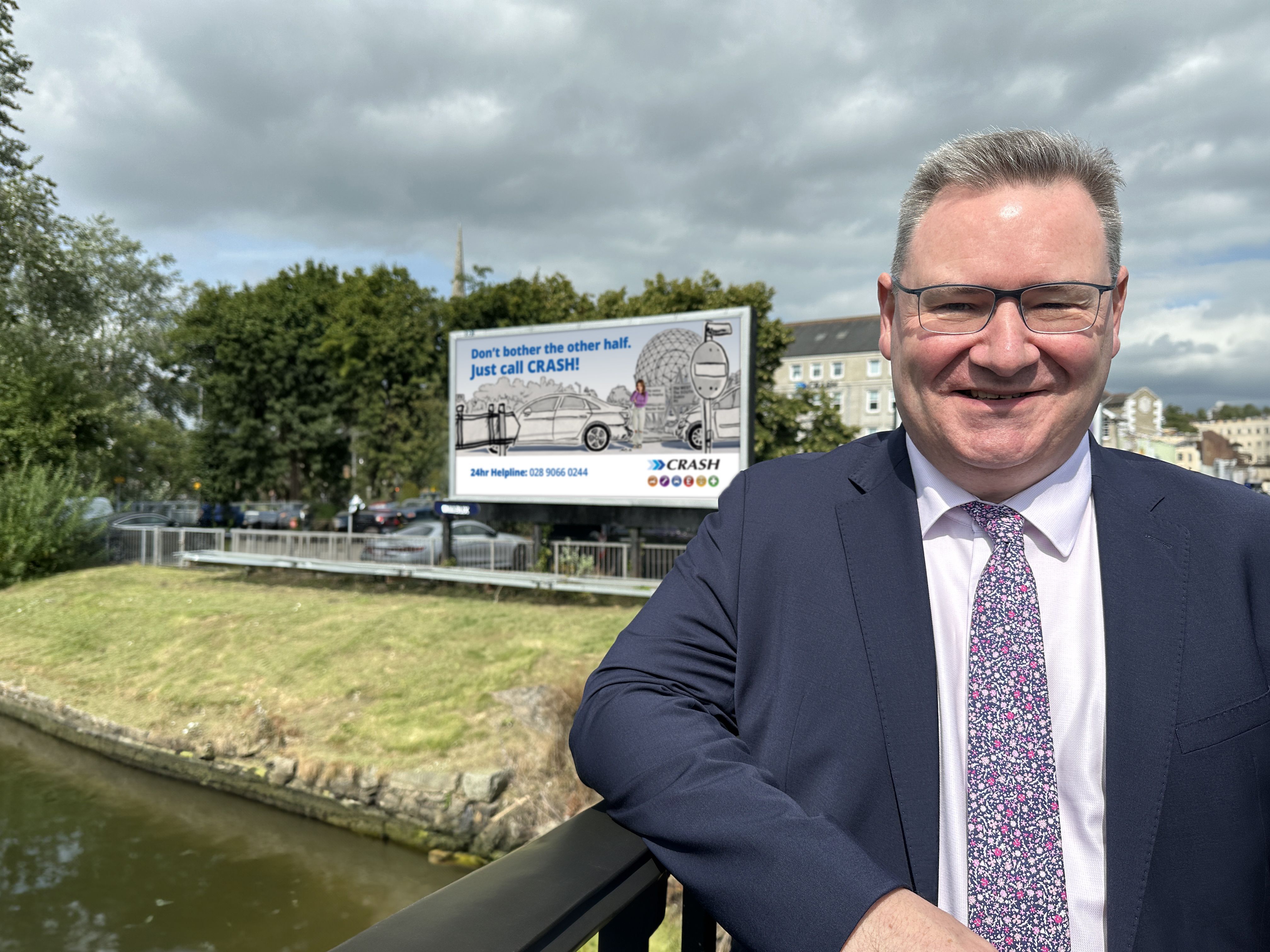 Jonathan McKeown (CEO of CRASH Services) beside one of the new Belfast-themed billboards