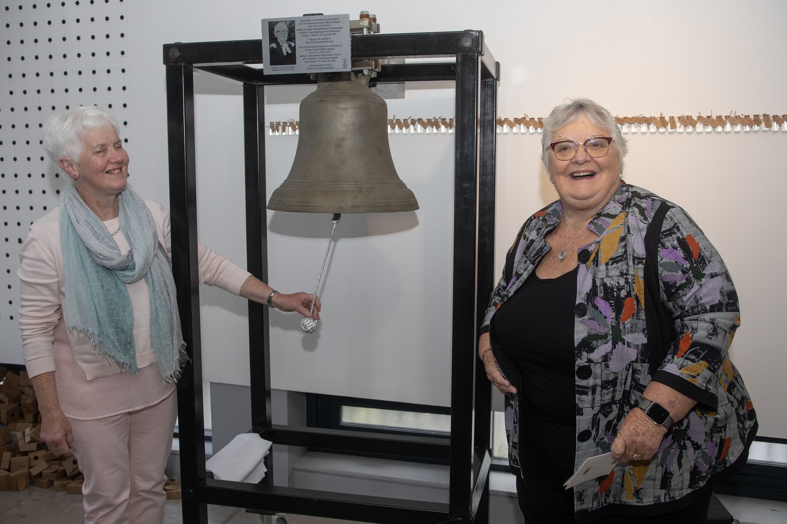 STRONG LINKS: Wilbur Gillespie’s daughters Helen McKelvey, right, and Alison McClure unveil the plaque to their father and ring the bell of Broadway Presbyterian Church in the Cultúrlann