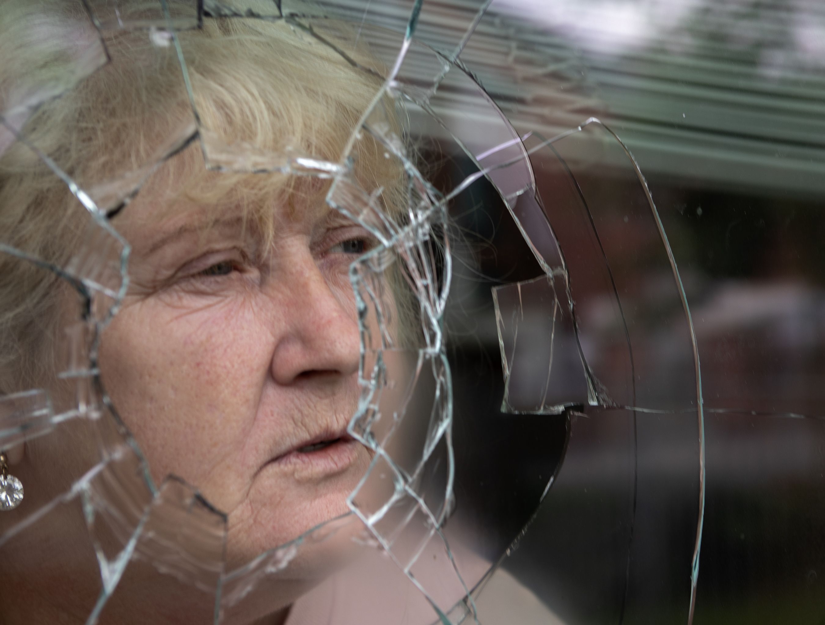 WINDOW SMASHED: Rosaleen Hynes peers through the shattered glass