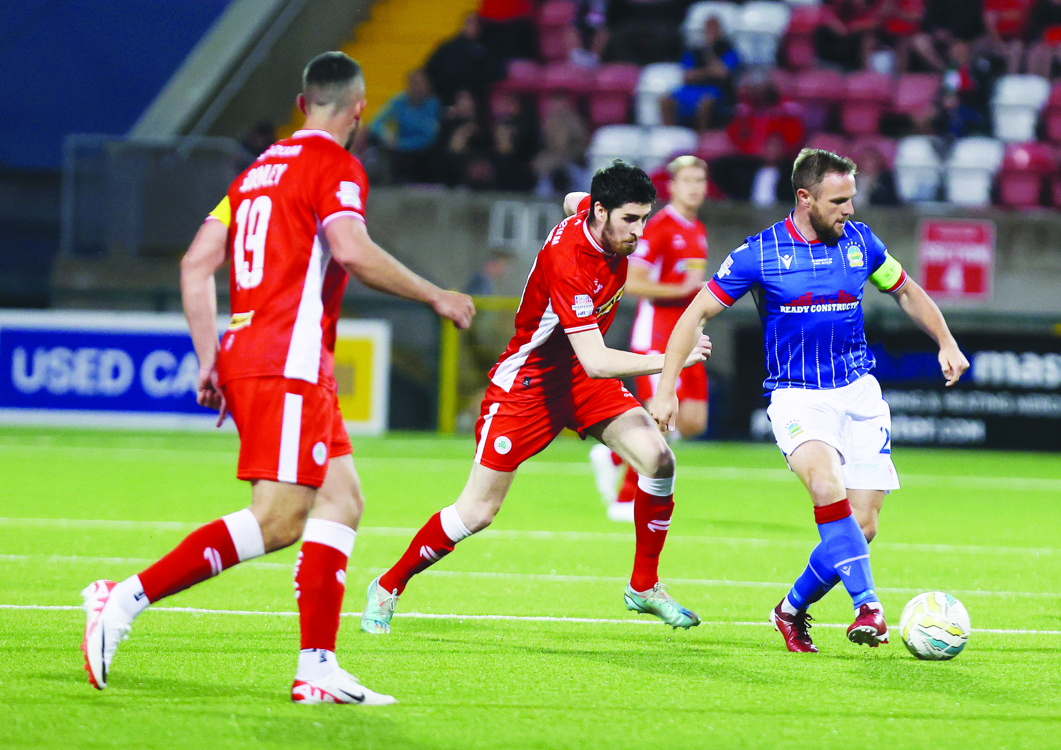 Kris Lowe (centre) - in action against Linfield earlier this season - is available for Saturday’s trip to Windsor Park  