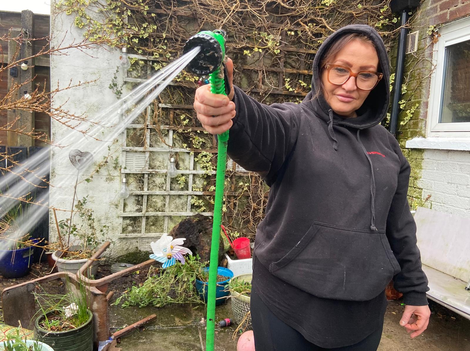 SPRAY DOWN: Angela Kane hosing down her Highfern Gardens garden