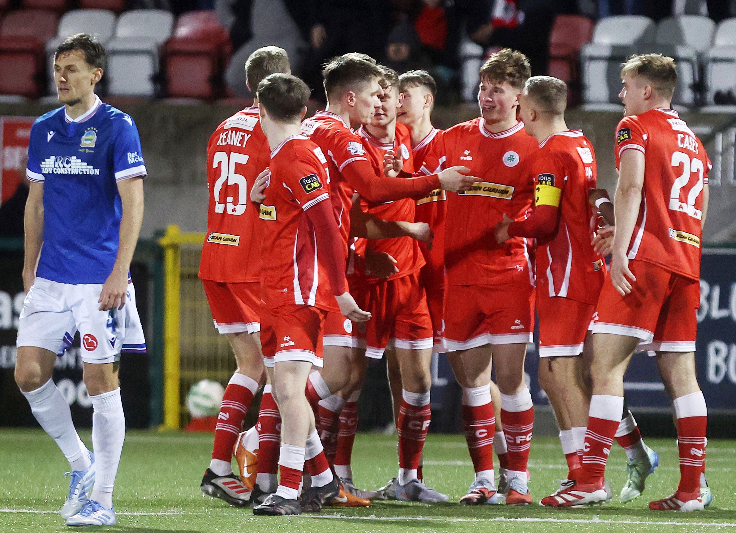 BACK ON FORM: Thomas Lavery is swarmed as he sealed the victory over the Windsor Park side