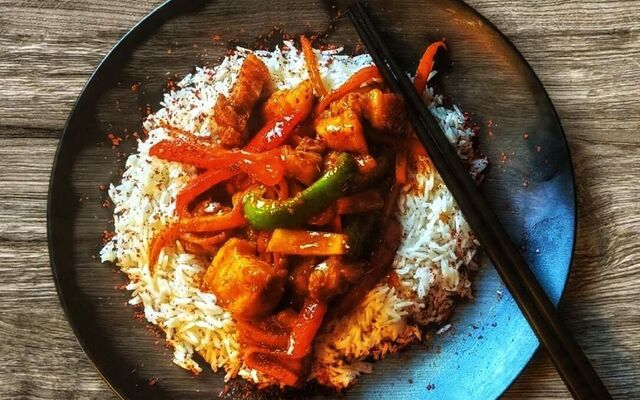 PLATING UP: Kung Pao chicken on steamed rice with a red pepper seasoning