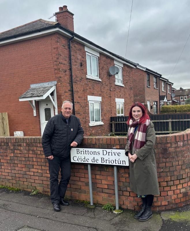 FÁILTE: Sinn Féin councillors Séanna Walsh and Róis-Máire Donnelly at a new sign in Brittons Drive in the Gaeltacht Quarter 