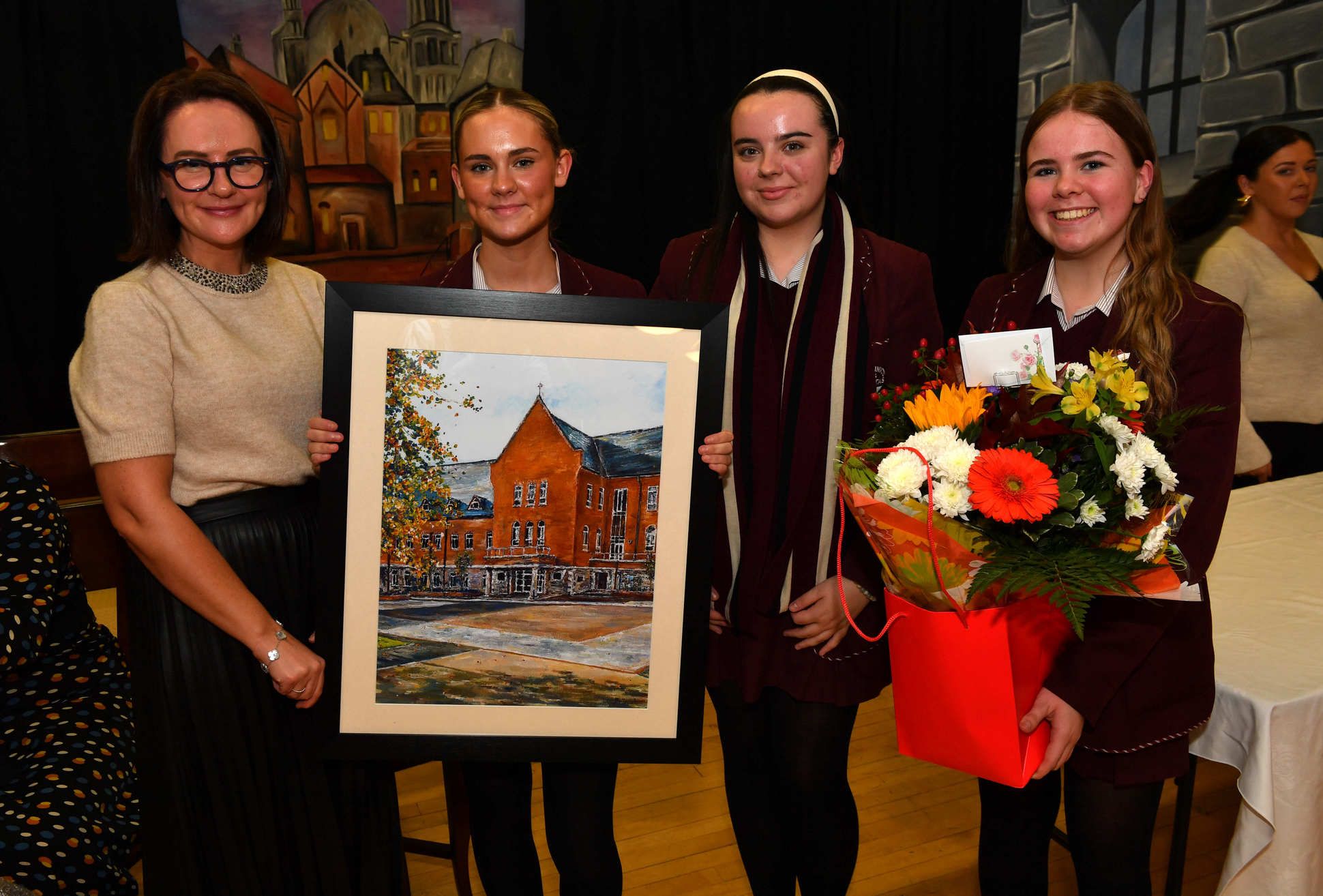 Head girls Eve Conlon, Nina Barkley and Erin Rice present guest speaker Dr Nichola Booth with a painting of the school as a gift