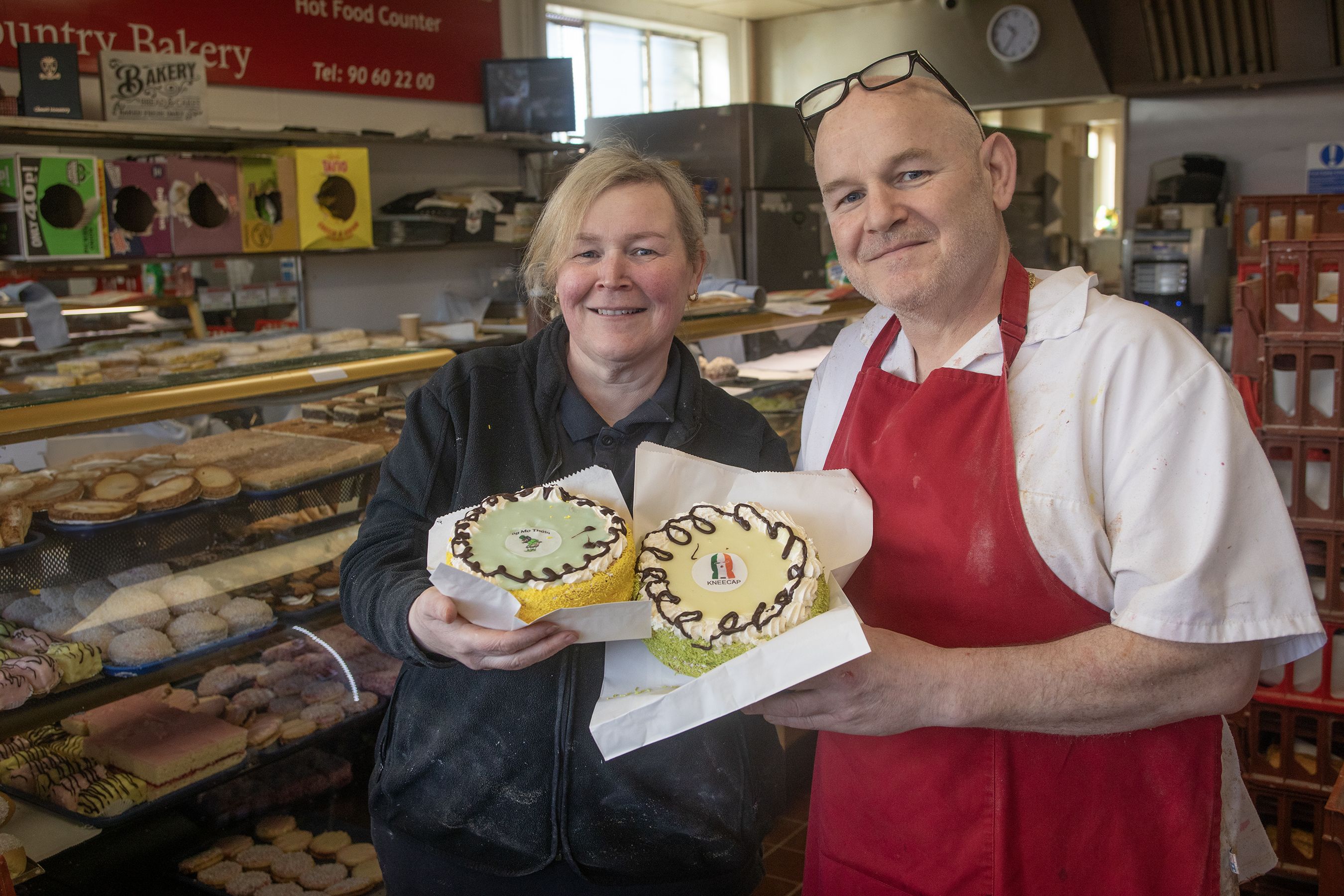 GREAT CRAIC: Owners of Smyth\'s Bakery in Andersonstown, Joanne and Jim Smyth with their Kneecap and Póg Mo Thóin cakes