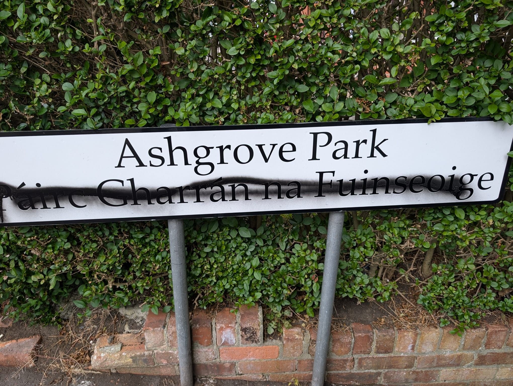 TARGETED: The dual-language sign in Ashgrove Park after the Irish words were spray-painted over