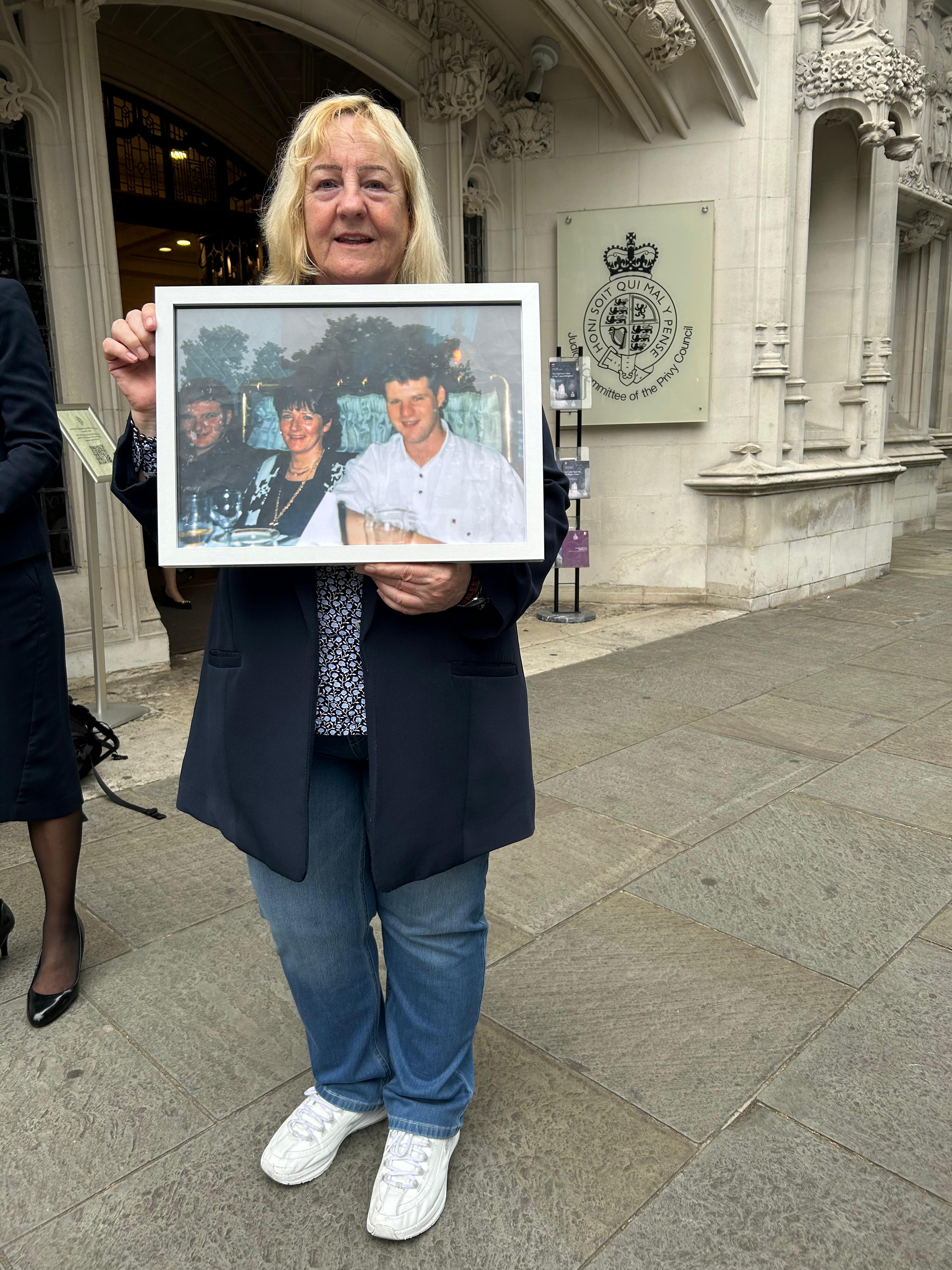 TEST CASE: Paul \'Topper\' Thompson\'s cousin Briege Wright outside the Supreme Court in London this morning holding a photo of Paul, left, mum Margaret and Eugene