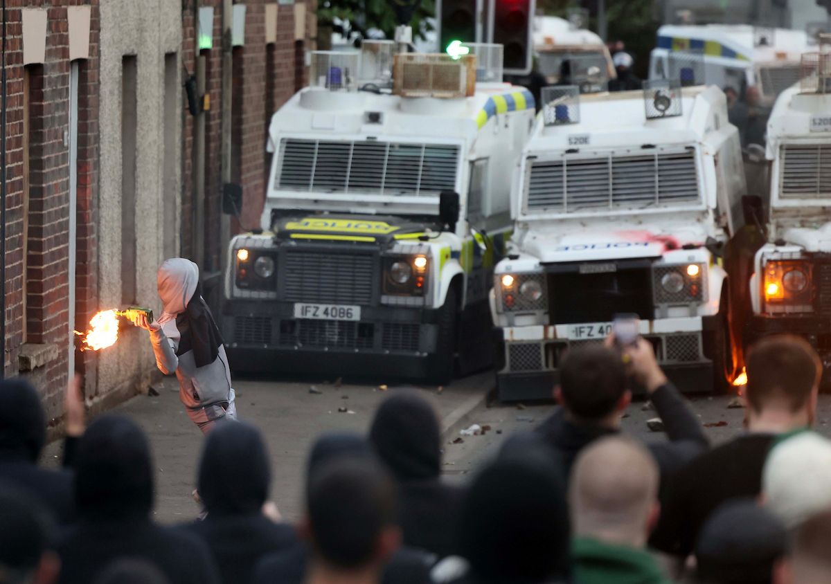 LINE OF FIRE: A young petrol-bomber lobs towards police in Ballymena during racist riots