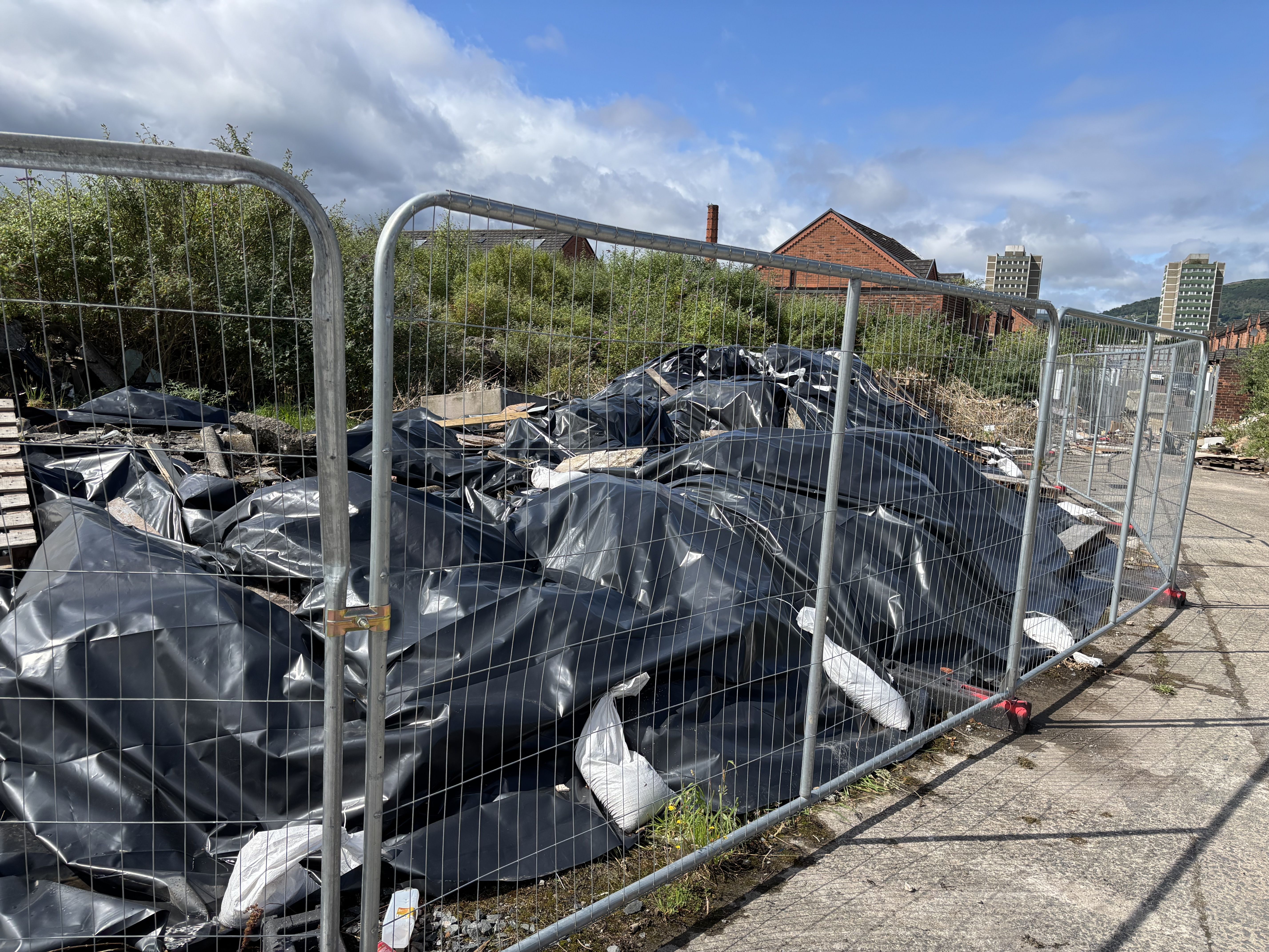 \'AMATEUR HOUR\': The huge pile of asbestos is \'secured\' by a plastic sheet held down with scrap wood and sandbags
