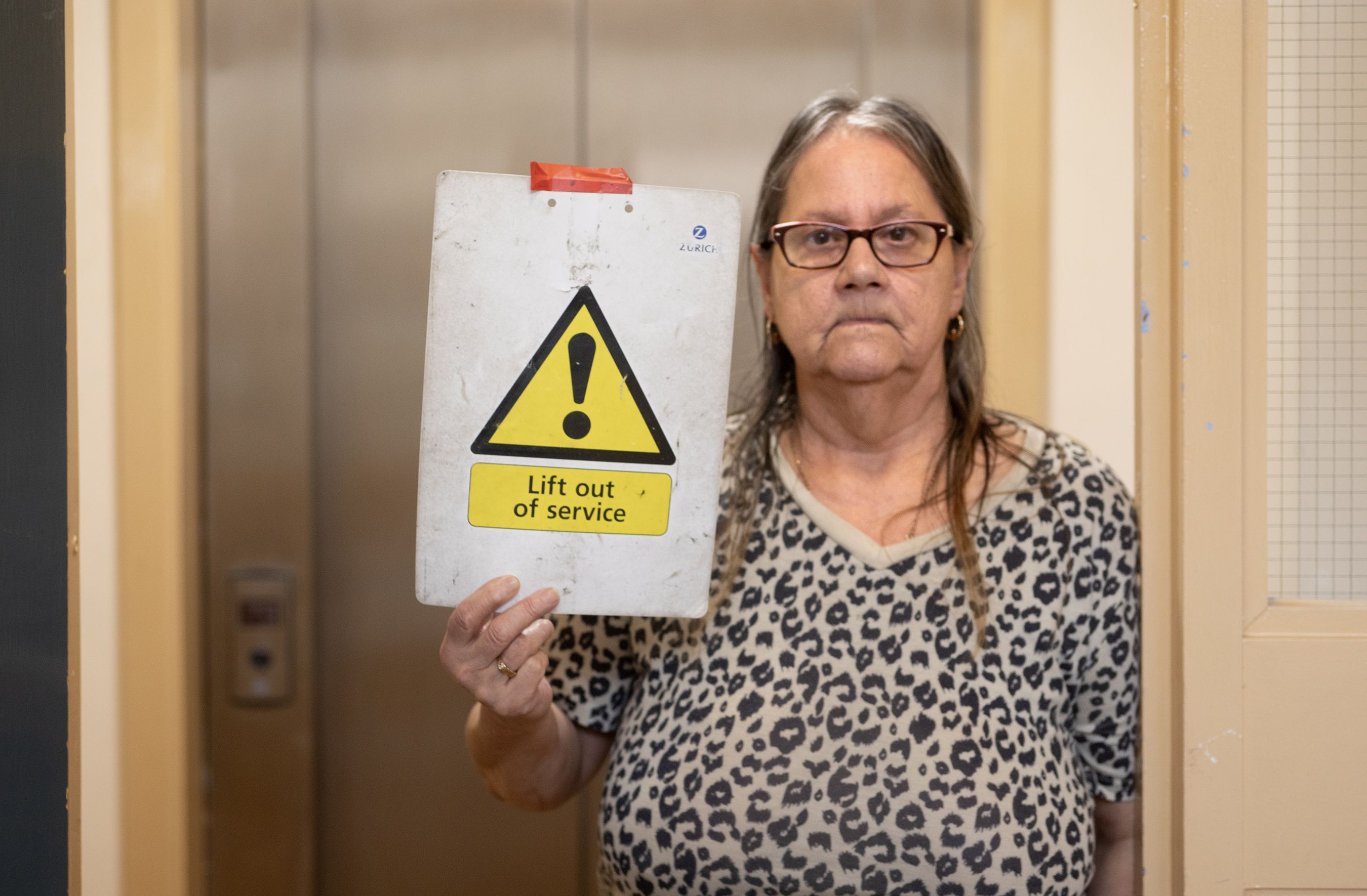 ANGER: Christine Hutcheon at the broken lift at her apartment complex