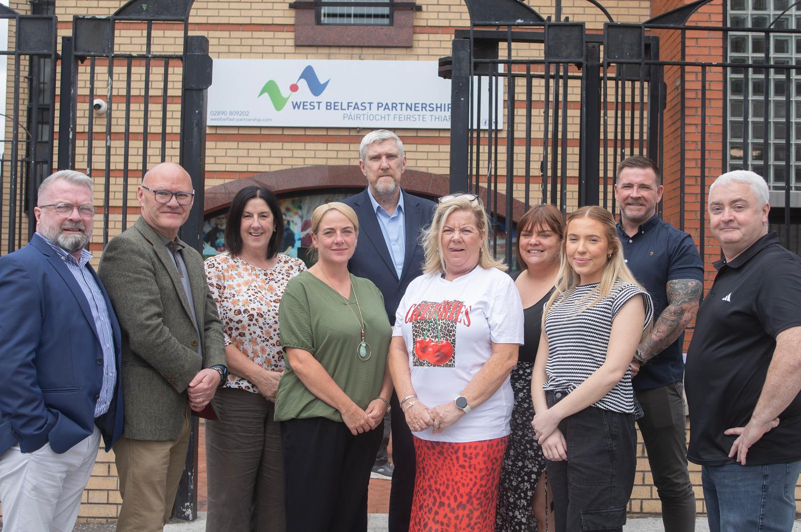 RIBBON-CUTTING: Minister O\'Dowd with staff of the West Belfast Partnership Board