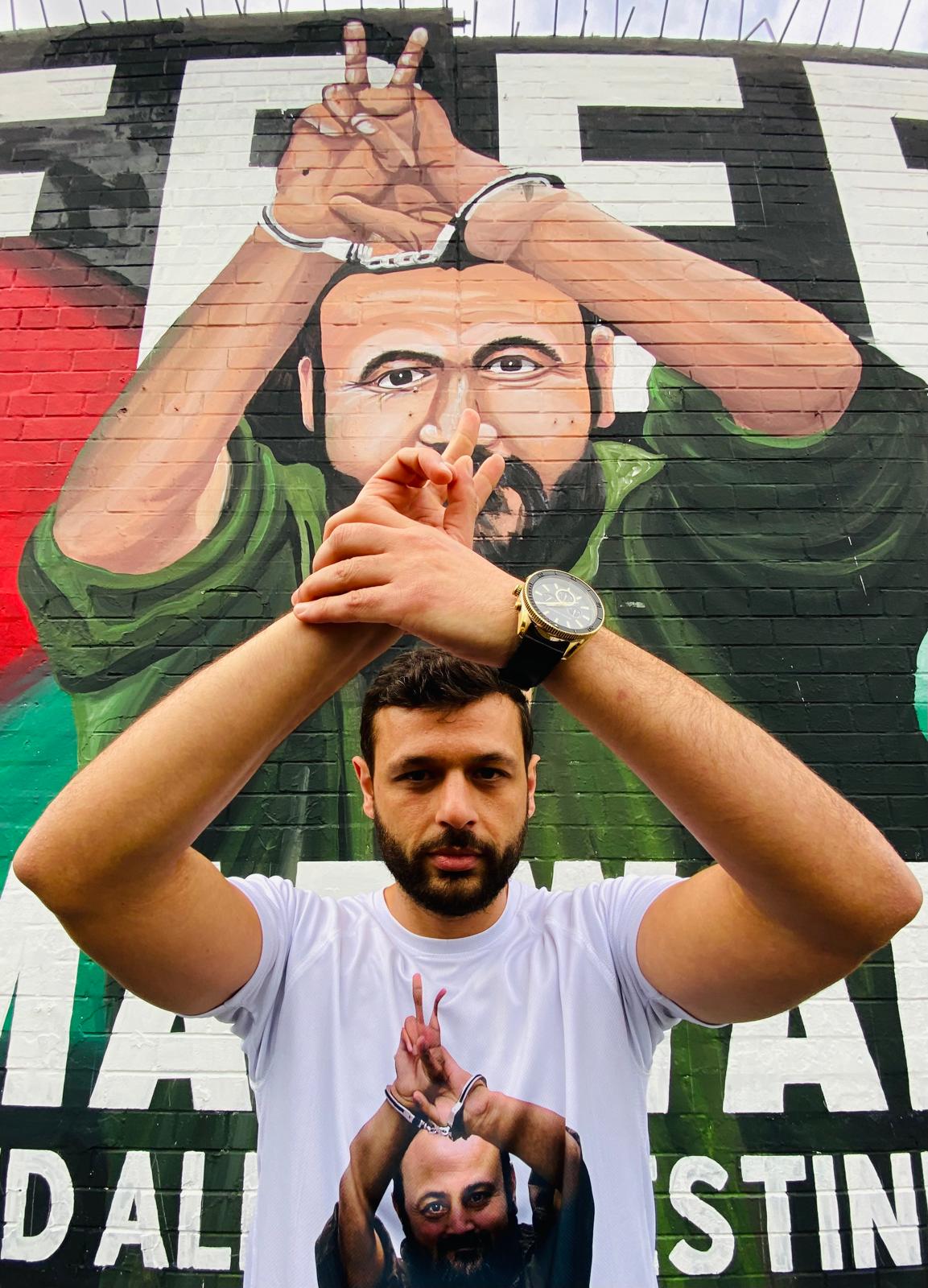 MURAL: Arab Barghouti at his father\'s mural on the International Wall on the Falls Road