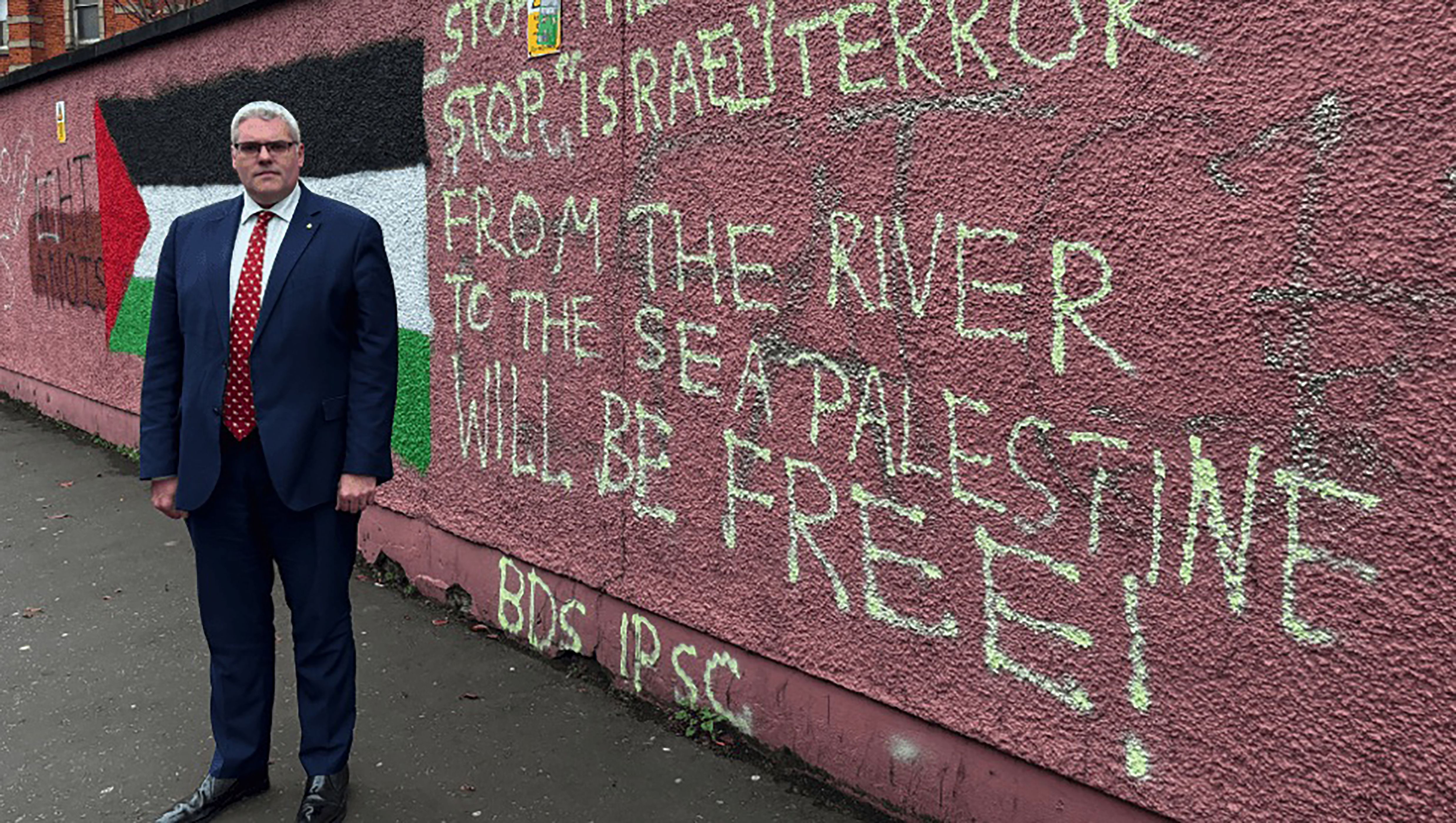 HEROIC: Gavin Robinson took his courage in his hands and went to West Belfast to get his picture taken beside Palestine graffiti