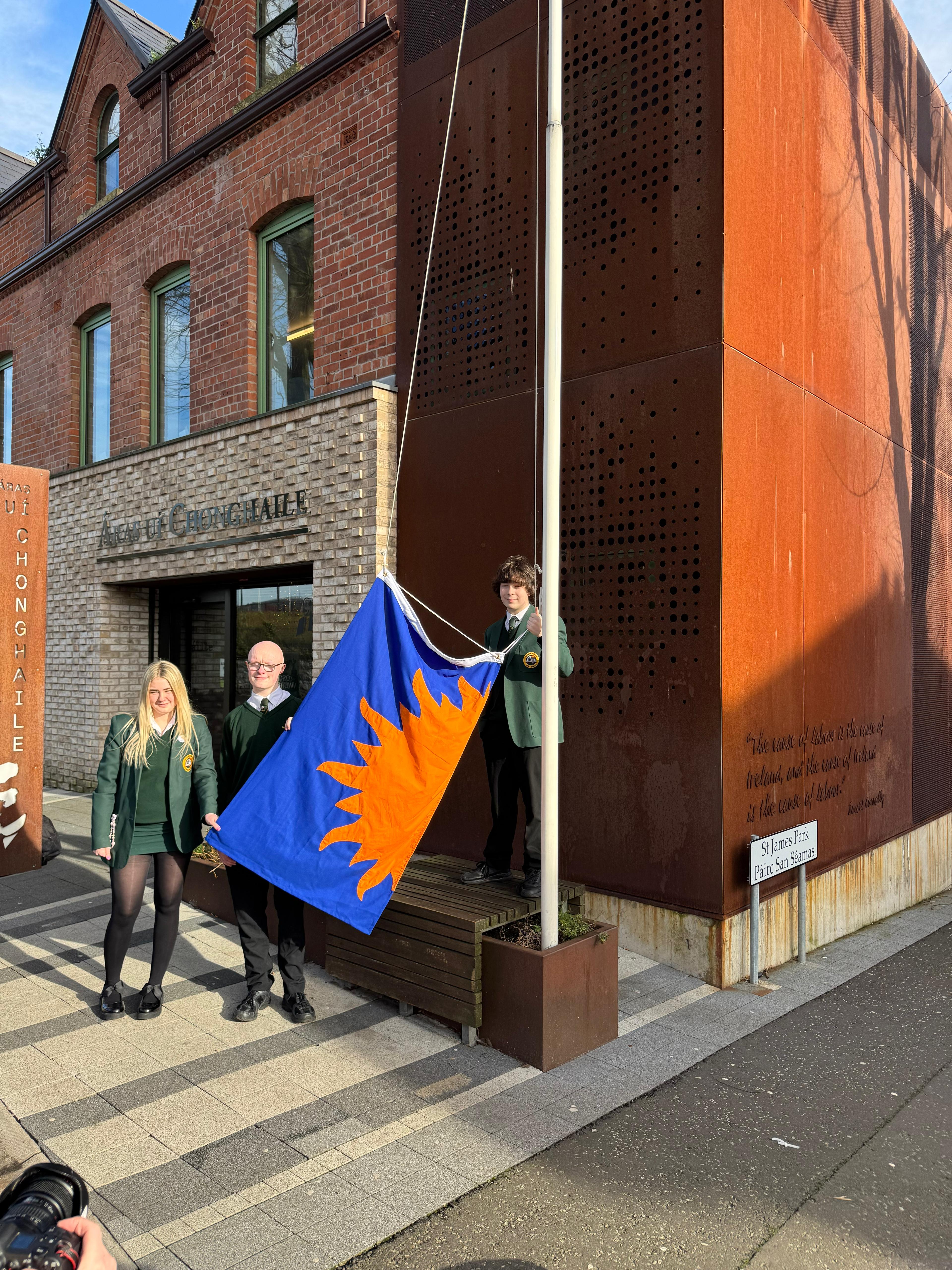 AN BHRATACH IN AIRDE: Dáltaí Choláiste Feirste ag ardú bratach Chonradh na Gaeilge ag Áras Uí Chonghaile an tseachtain seo