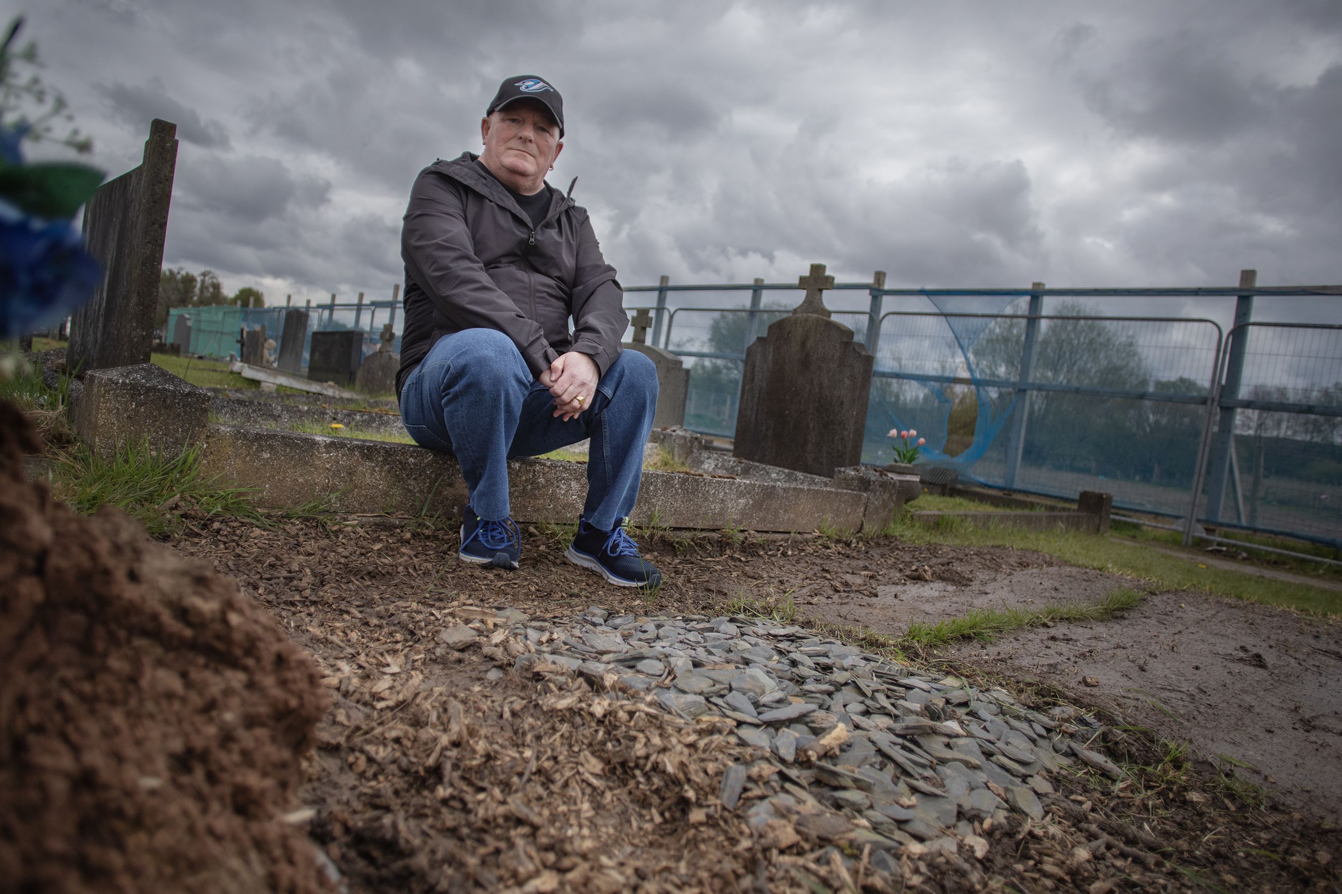 ANGER: Pat Neeson at his uncle Con\'s grave in Milltown Cemetery