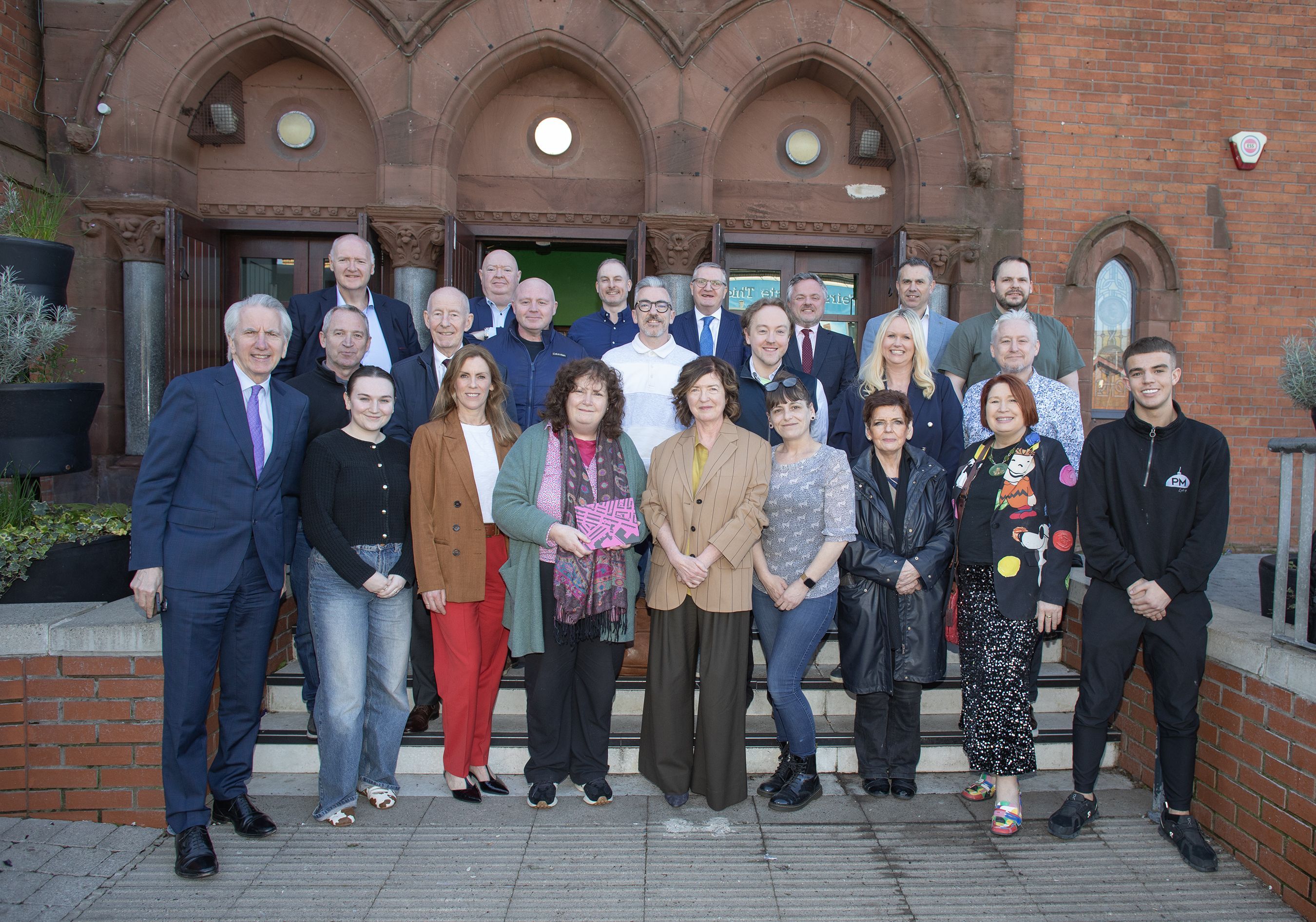 WARM WELCOME: Attendees at this morning\'s Small Business Circle with guest speaker Sue Gray centre right. She was presented with a copy of a book detailing the rebuilding of Bombay Street by the city\'s Irish language community.