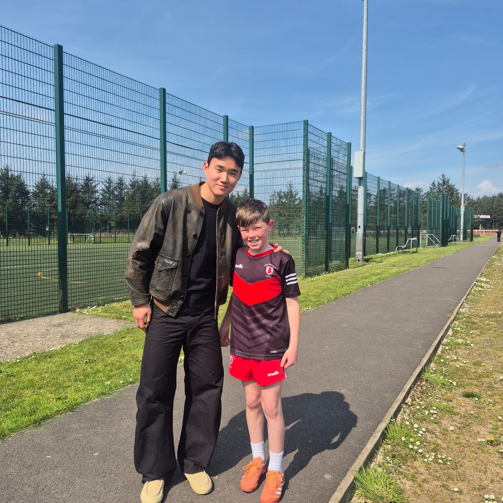 INTO THE WEST Celtic’s Hyun-Jun Yang, with a young Lámh Dhearg footballer, Conal Quinn