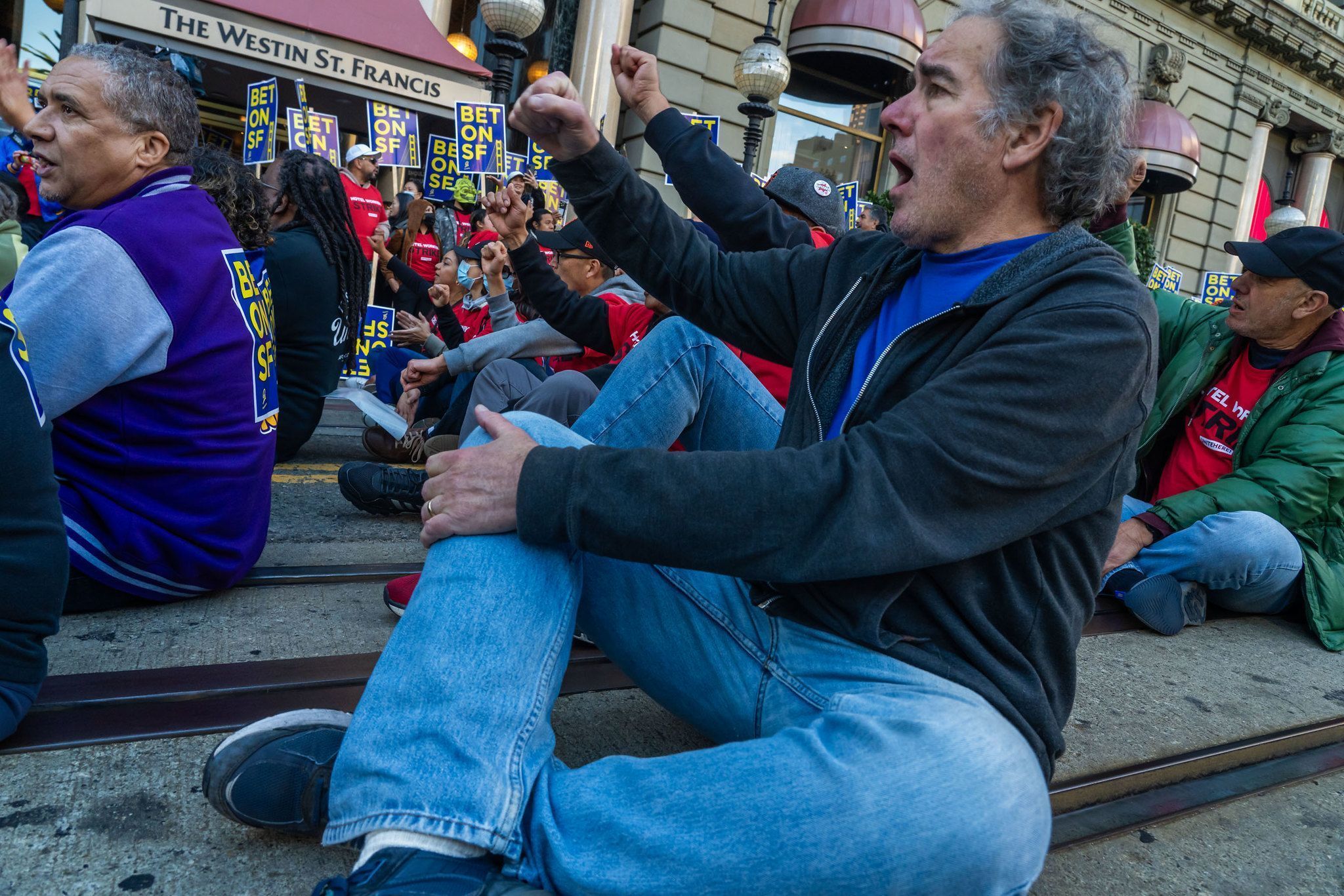 \"ONE DAY LONGER\": Mike Casey joins hotel sector workers with Unite Here Local 2 in a 2024 sit-down protest in the heart of San Francisco\'s tourist district which resulted in 88 arrests.