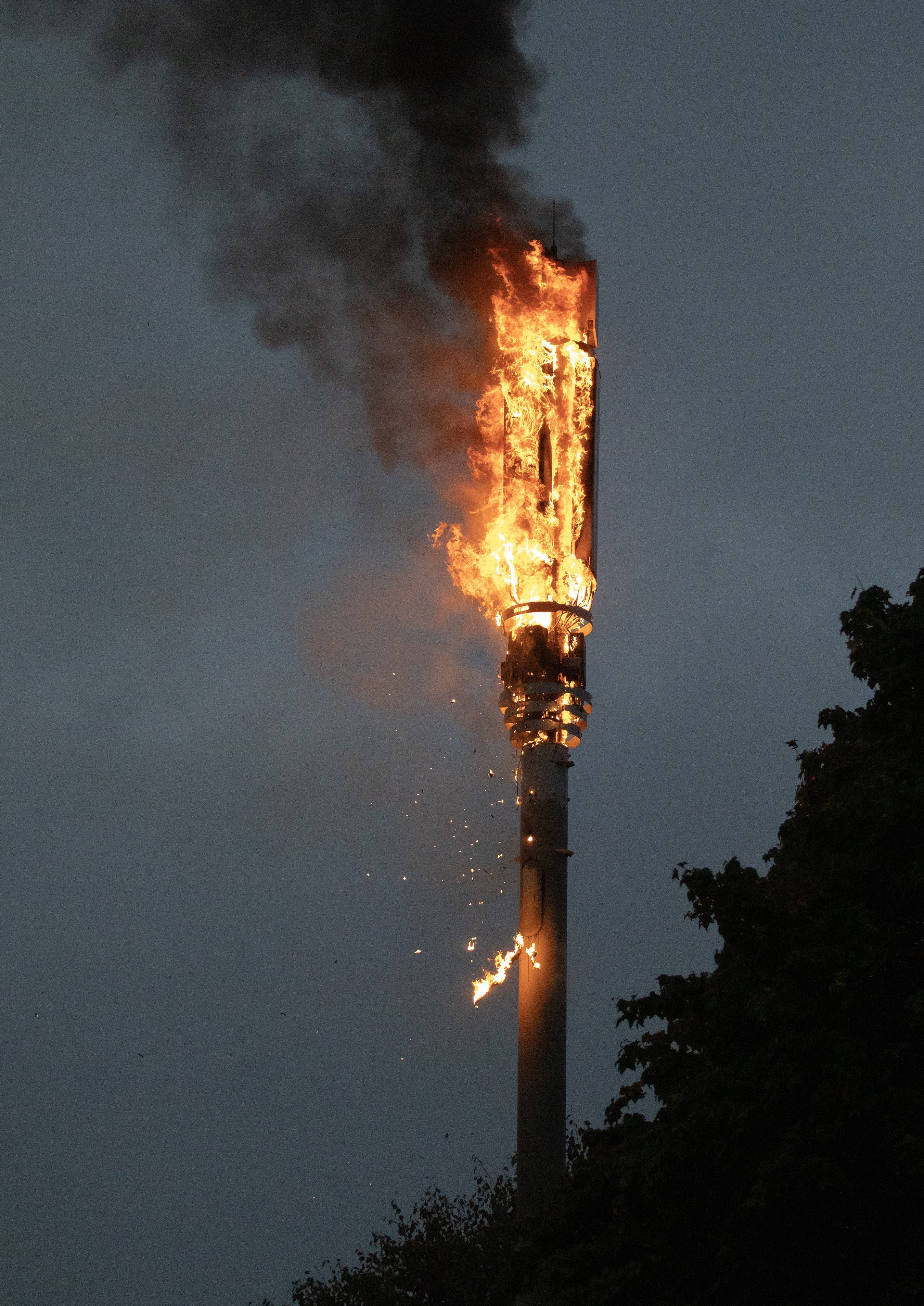 DAMAGE: A 5G mast on fire after being set alight