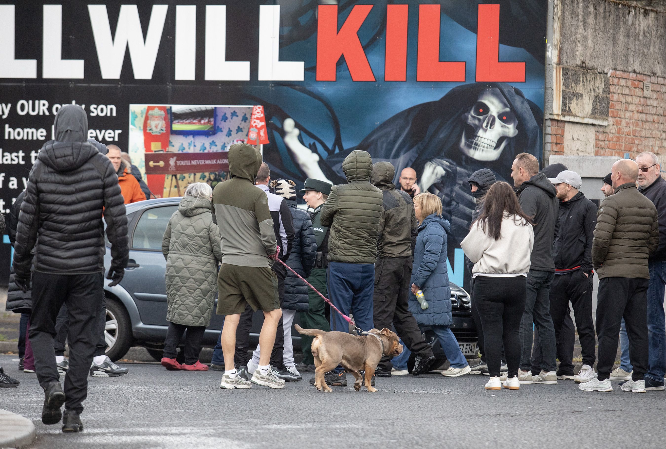 CROWD: A police officer intevenes after the car is stopped at Twaddell roundabout