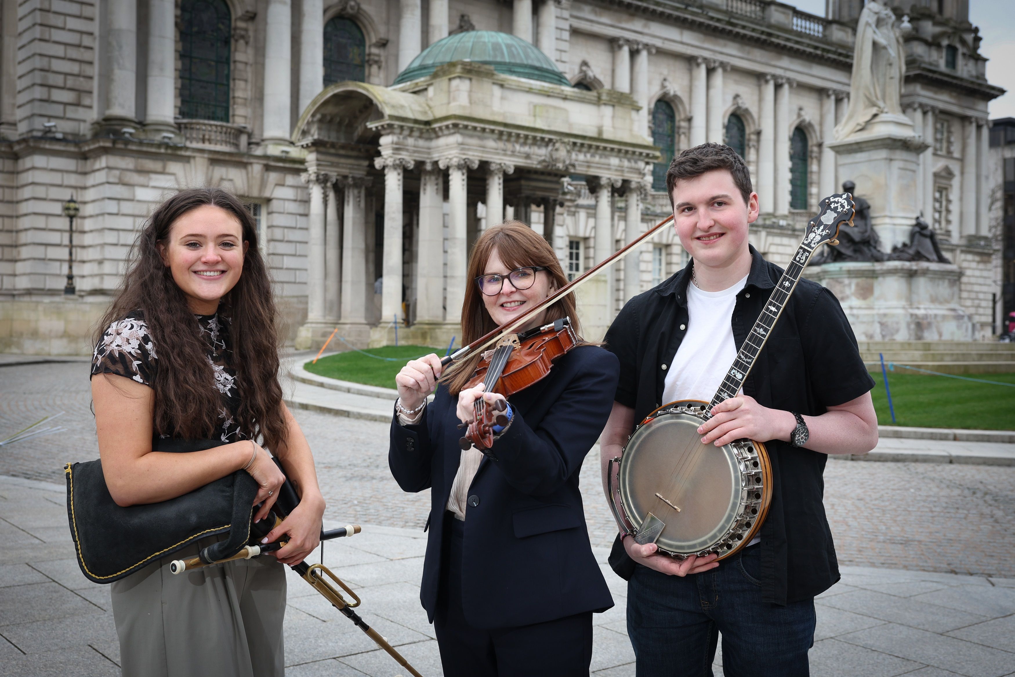 SWEET MUSIC: Economy Minister Dr Caoimhe Archibald with musicians Lily Moore and Ciarán McCusker from Ards Comhaltas