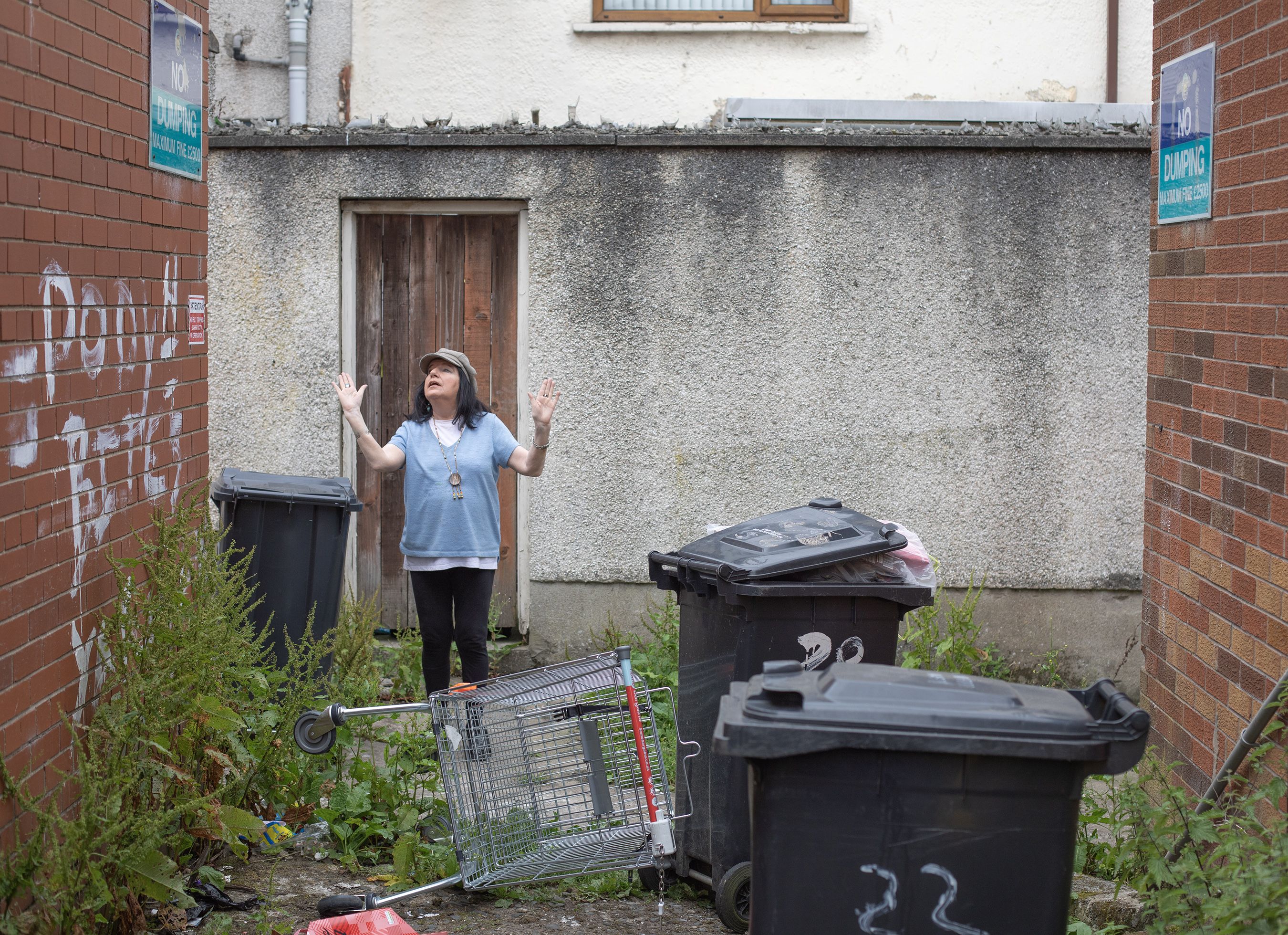 DESPAIR: Fionnuala Burke in her overgrown and rubbish strewn alleyway to the rear of her house
