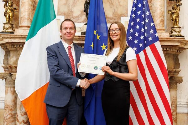 Iarscoláire Ollscoil na Banríona ag teagasc na Gaeilge i Meiriceá