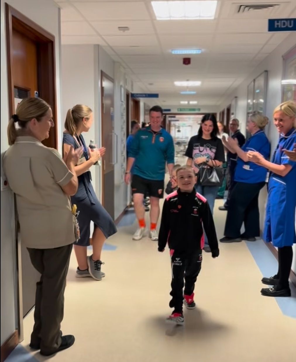 ALL SMILES: Dáithí Mac Gabhann leaves hospital with parents Máirtín and Seph