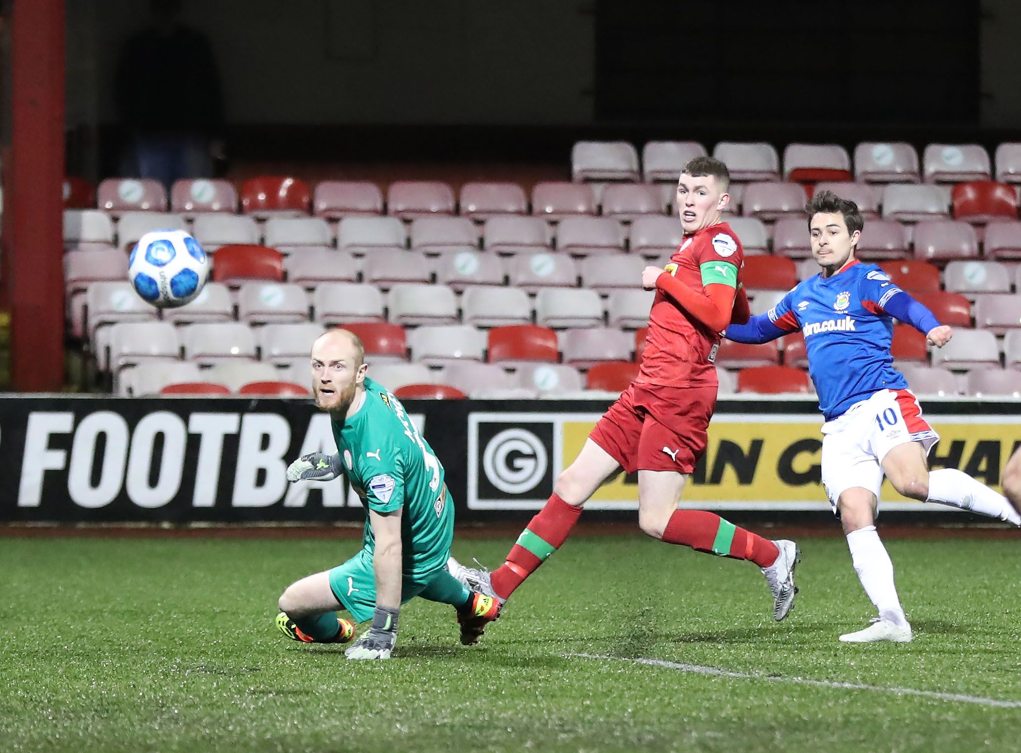 Jordan Stewart clips the ball over Aaron McCarey and into the net 