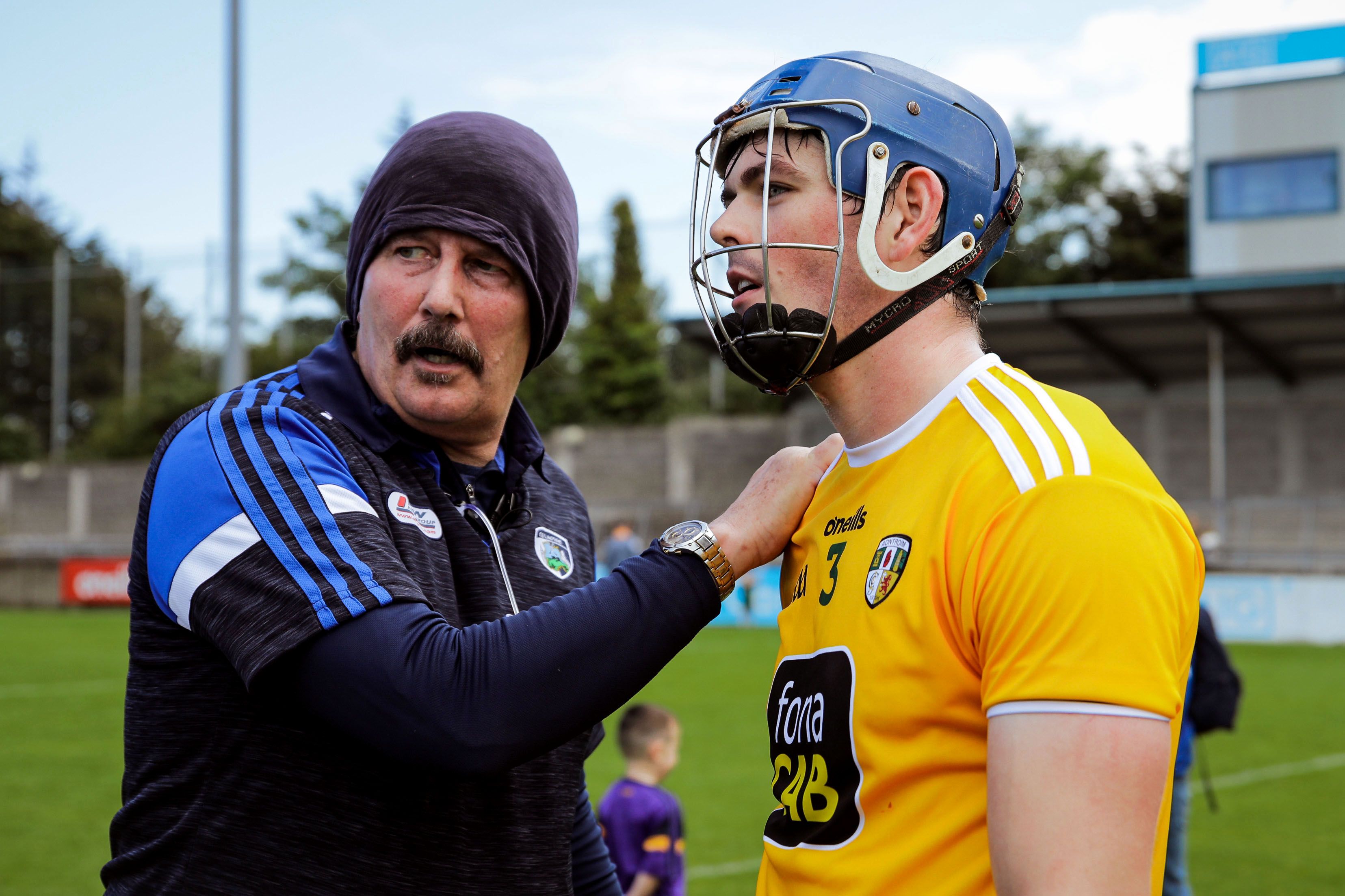Laois manager Seamus 'Cheddar' Plunkett commiserates with Antrim's Gerard Walsh 