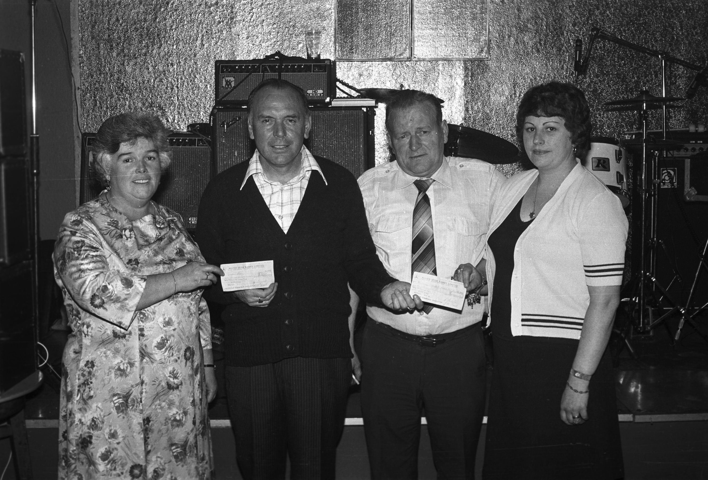 Geordie Shannon, manager of the Terry McDermott Social Club, Glen Road, presents libel-settlement cheques from the Sunday News to the Green Cross and disabled children of West Belfast charities