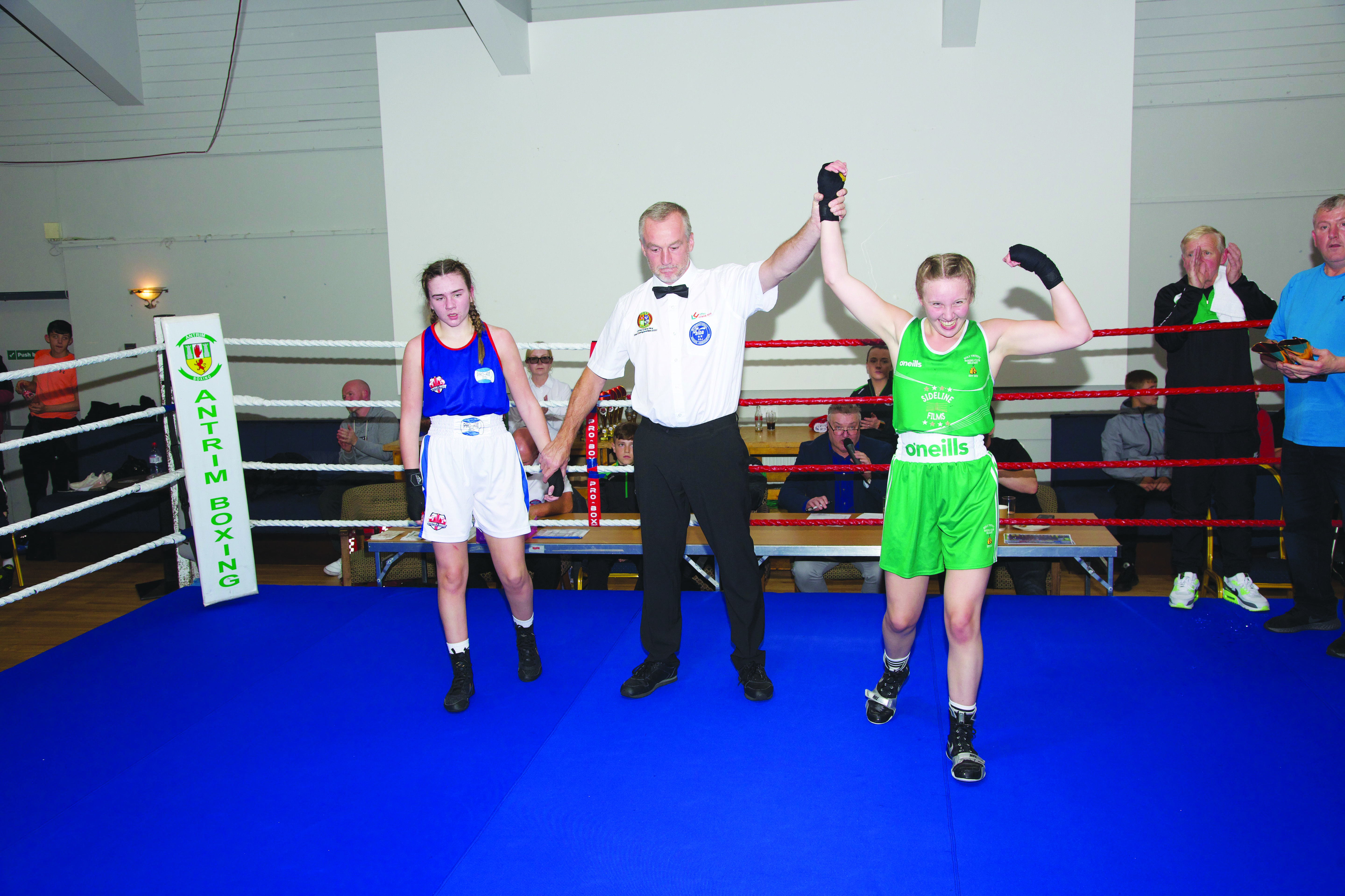 Referee Malachy Scott raises the arm of Holy Trinity ace Summer Fleming after victory over Jolie Murphy while coach Michael Hawkins and Trinity legend Eddie Fisher (right) look on
