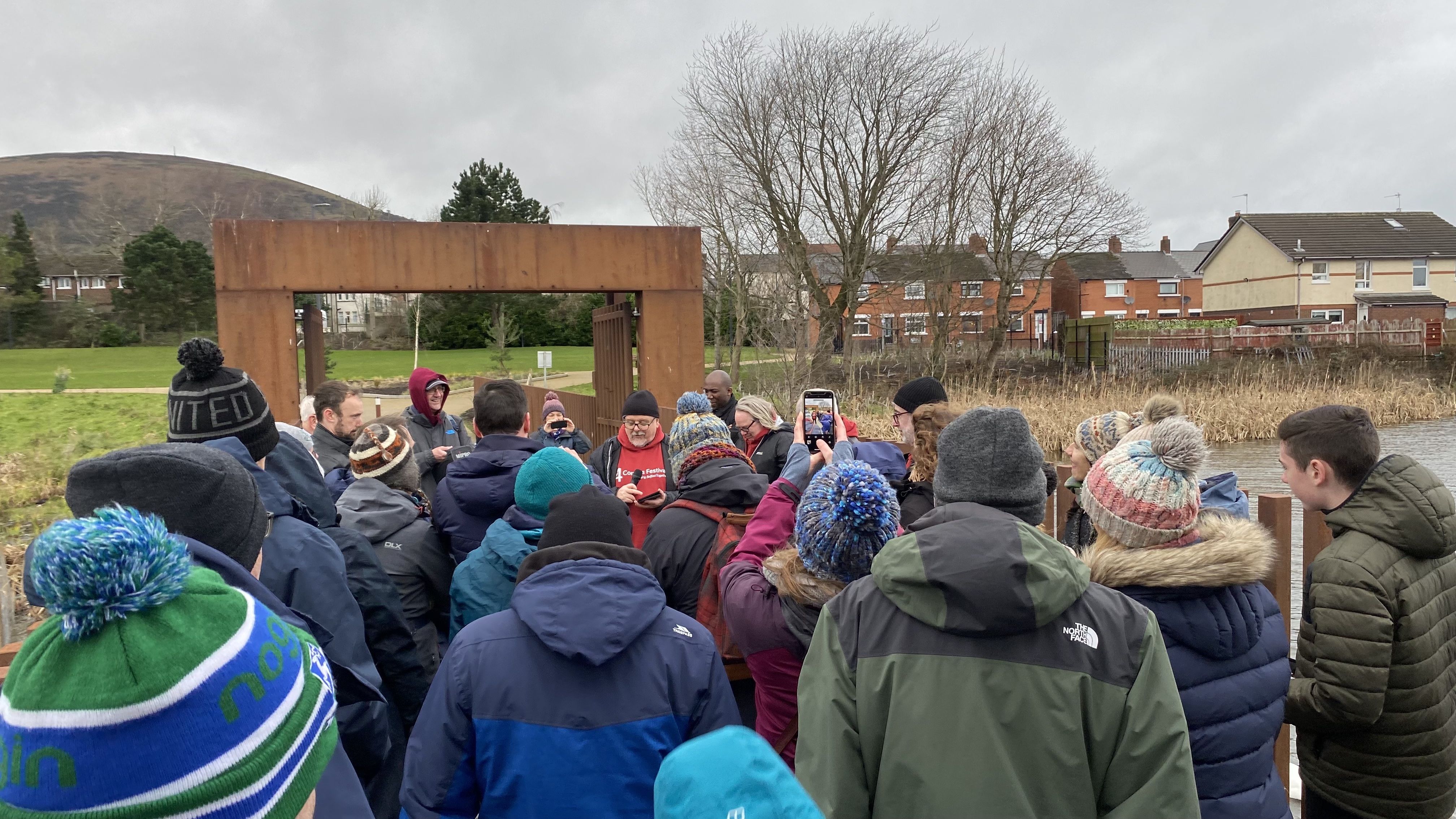 BRIDGE OVER TROUBLED WATERS: 4 Corners Festival walkers pause at the bridge at the new Farset Dam park to welcome the Archbishop of Canterbury Justin Welby