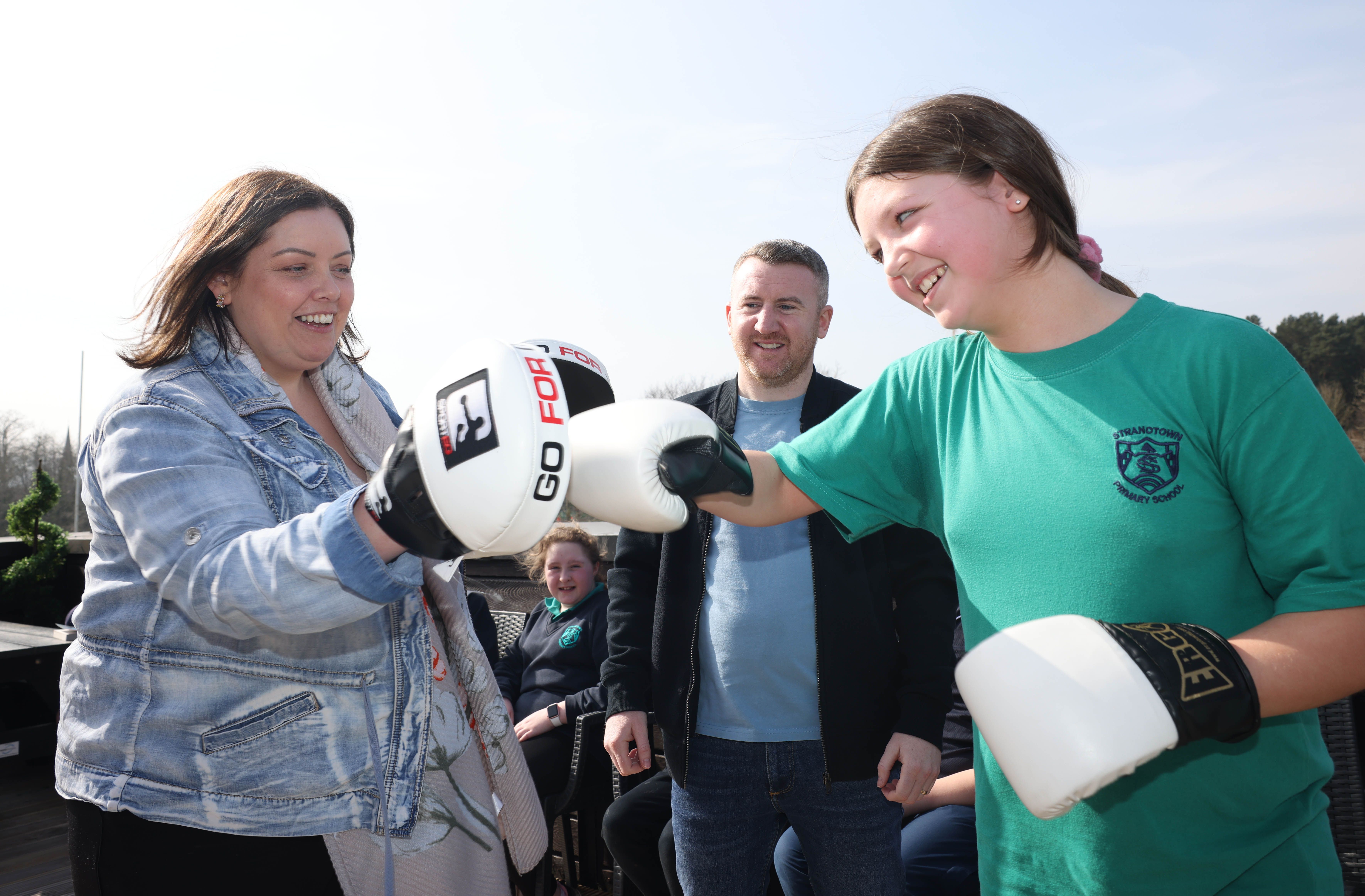 Casey Cunningham of Strandtown Primary School, Belfast has some fun sparring with   Communities Minister, Deirdre Hargey during a boxing coaching session 