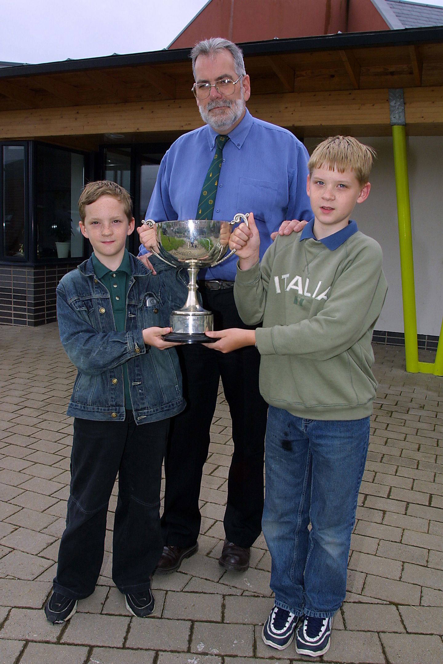OIDEACHASÓIR: Diarmuid ina phríomhoide ag bronnadh Corn Mhic Eachaidh sa scoil.
