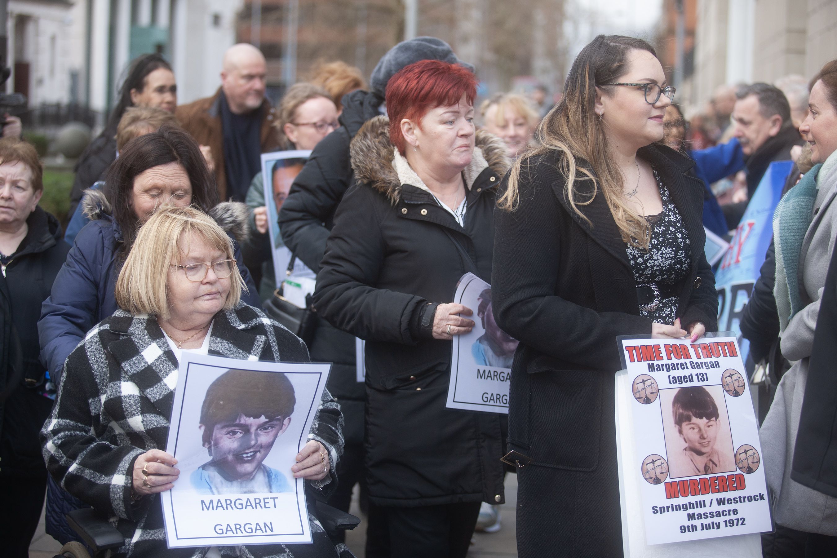 Families hold photographs of those who died