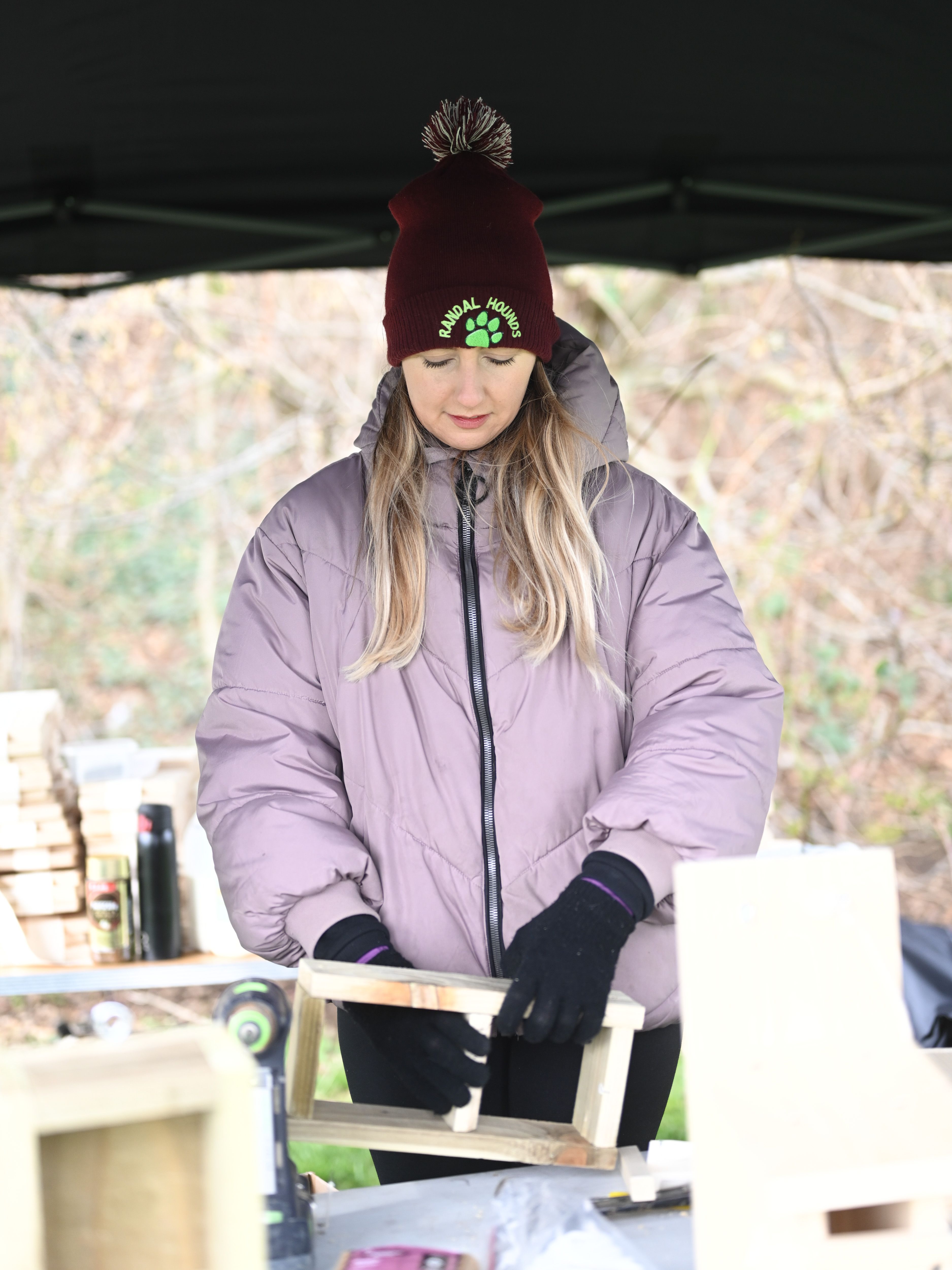 BUILDING: Alicia building a birdhouse for the trees beside the field