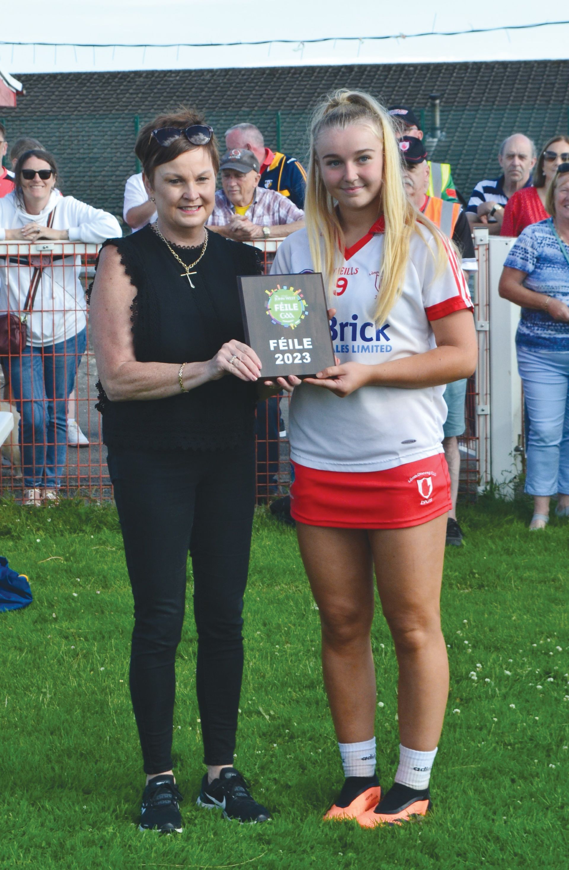 Lámh Dhearg captain Amelie Annett accepts the trophy 