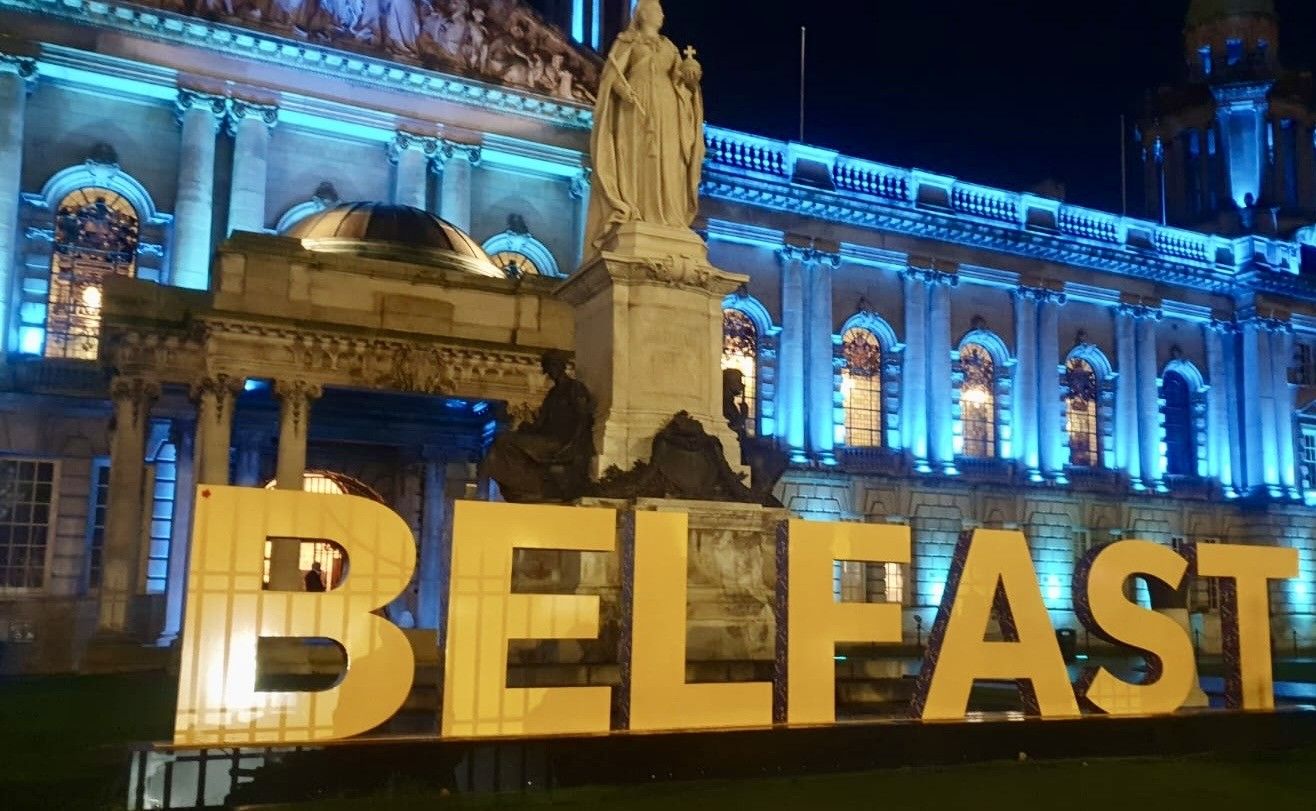 Belfast City Hall lit up in the credit union colours