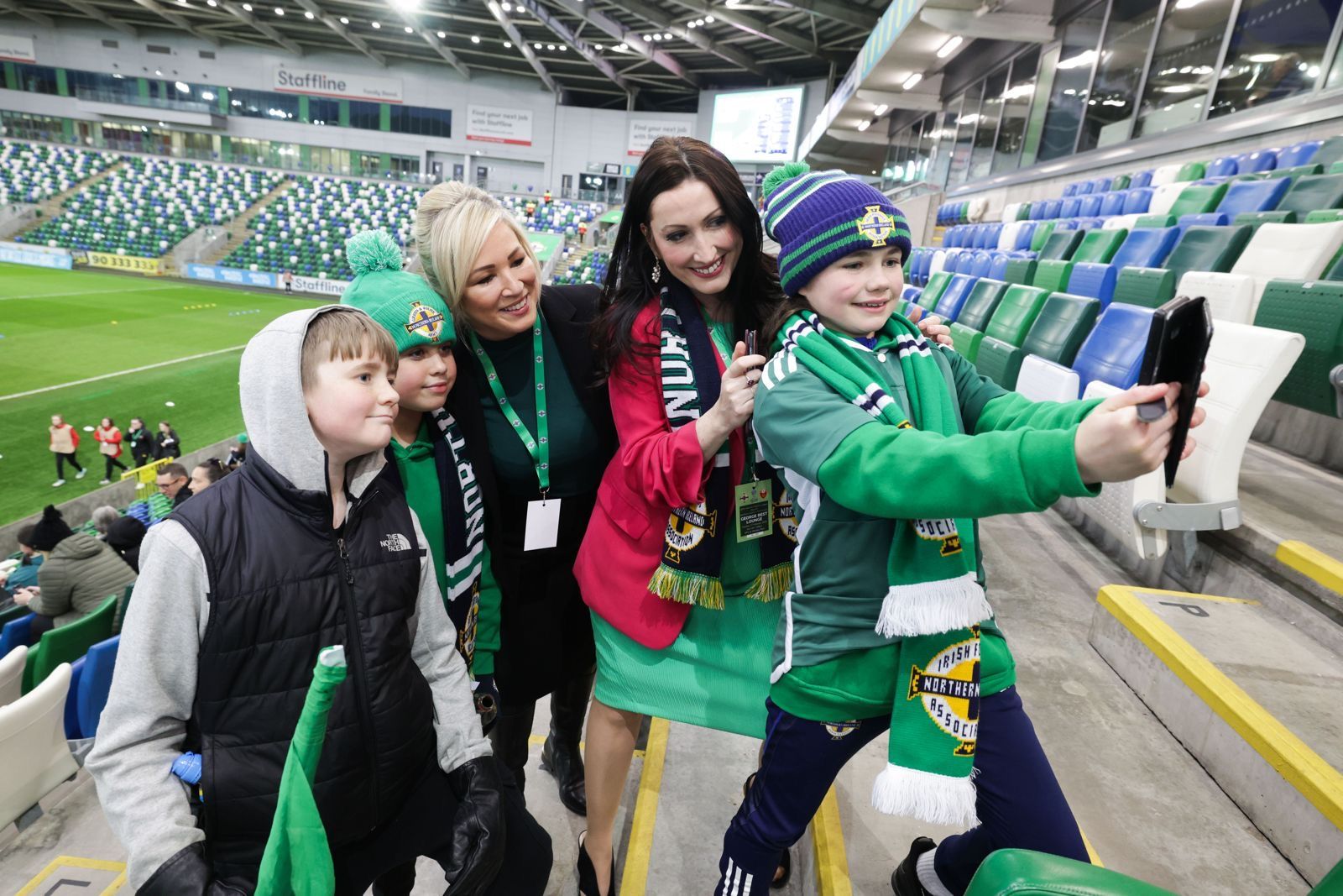 First Minister, Michelle O'Neill and deputy First Minister, Emma Little-Pengelly pictured at Windsor Park with some young football fans before the start of the senior women's match.