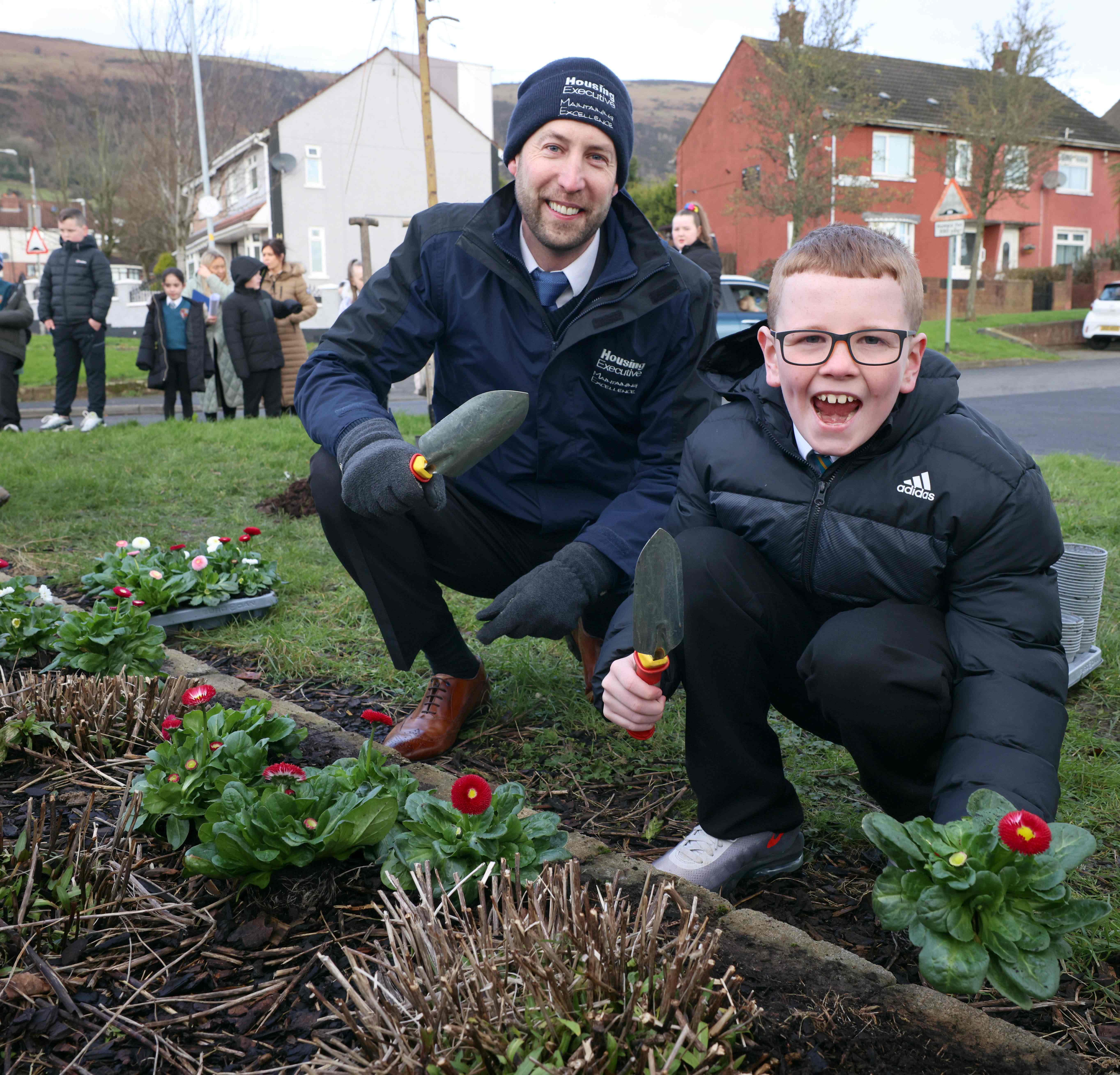 P5 pupil Caoimhghin with the Housing Executive’s grounds maintenance supervisor John Ingram
