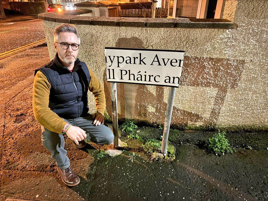 VANDALISM: Cllr Gary McKeown at the Haypark Avenue sign when it was damaged in February