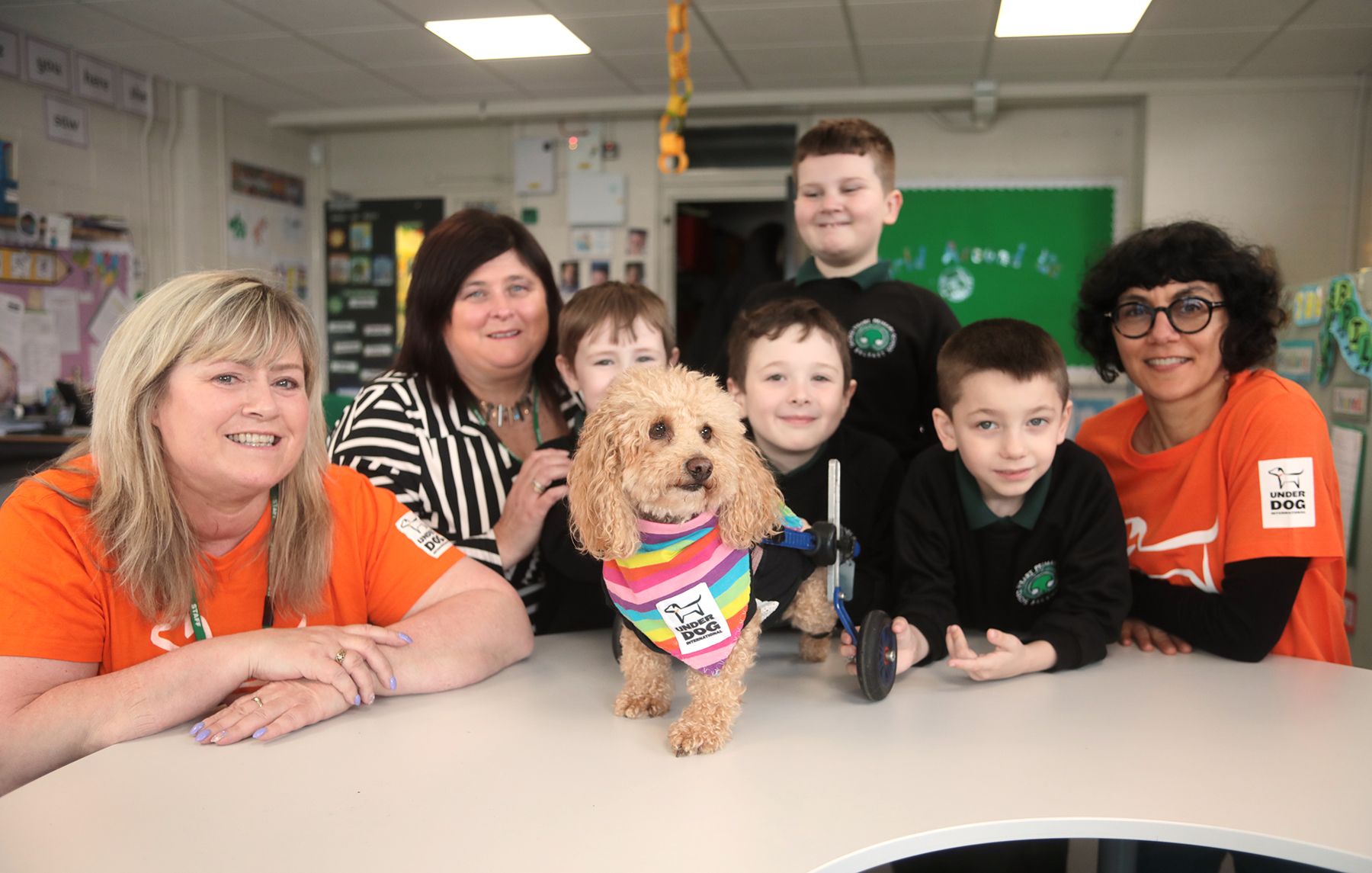 CHARITY: Henry Wee Wheels with his owner Sharon (left), Principal Joanne Smyth, pupils from Sacred Heart and Nadine Kayser from Underdog International