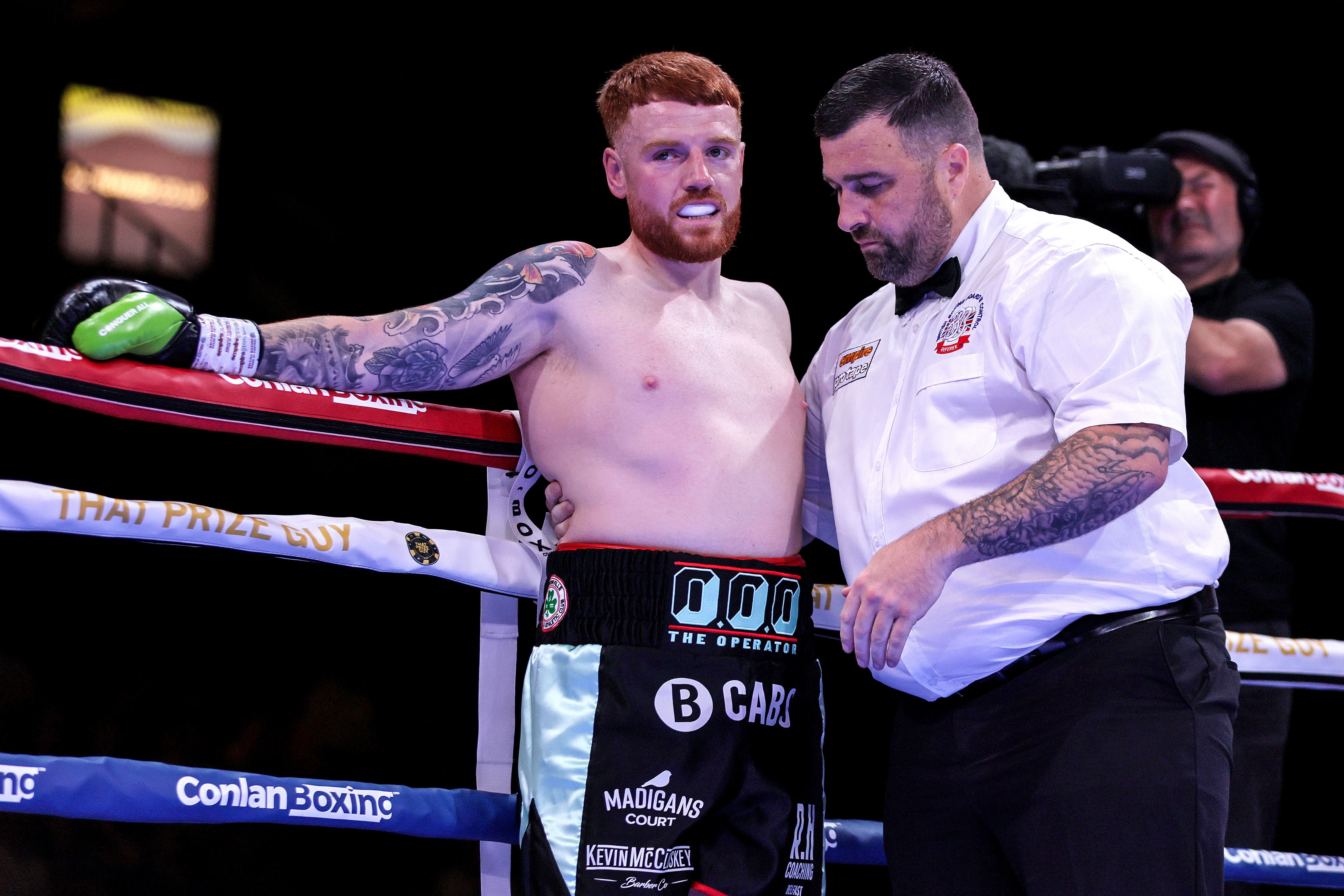 Owen O'Neill is helped by referee Eamonn Magill following his loss to Dylan Moran