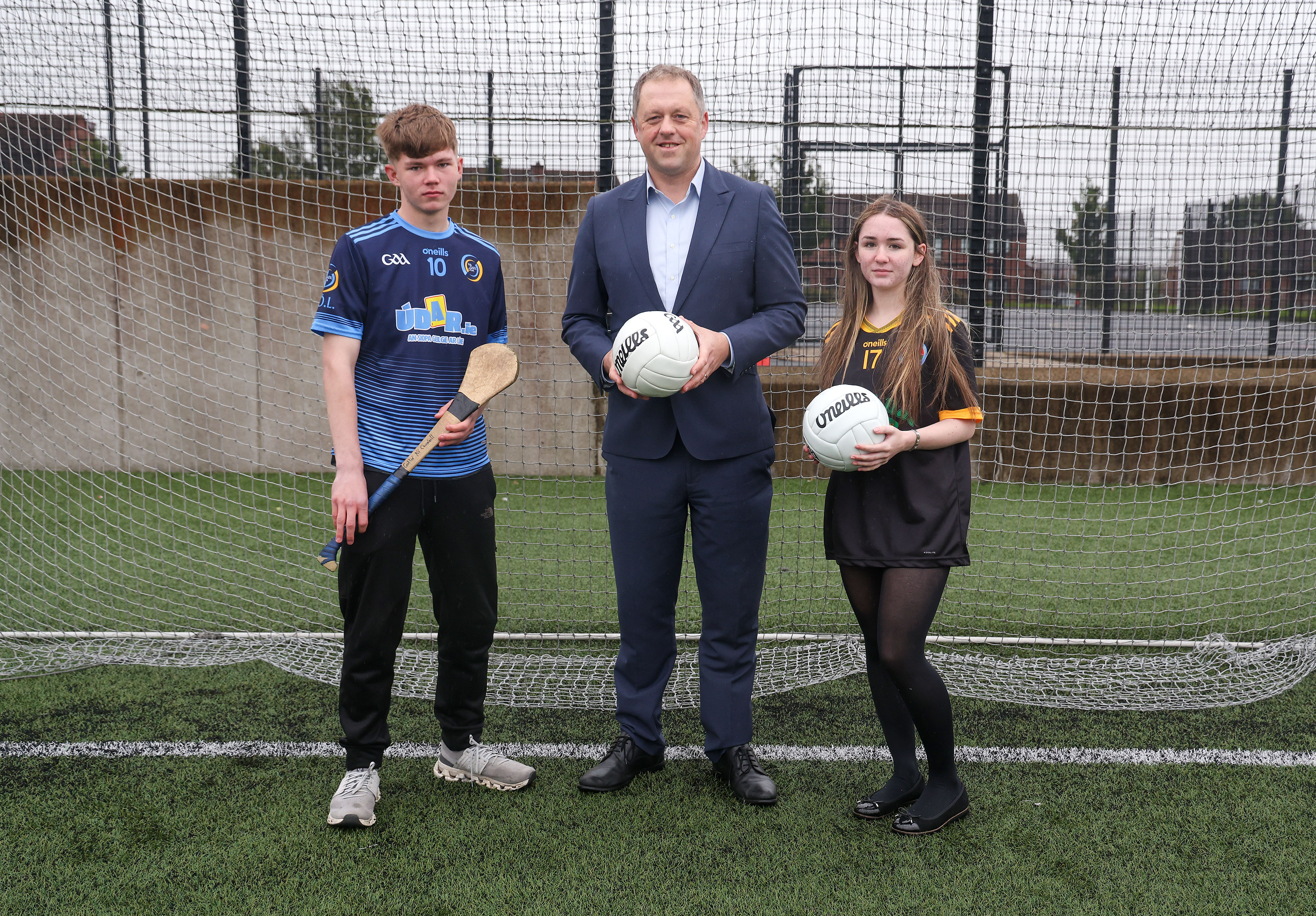 Minister for State Thomas Byrne TD with CLG Laochra Loch Lao and Na Gaeil Óga players at West Belfast’s Spórtlann na hÉireann at the launch of today’s Irish language support scheme