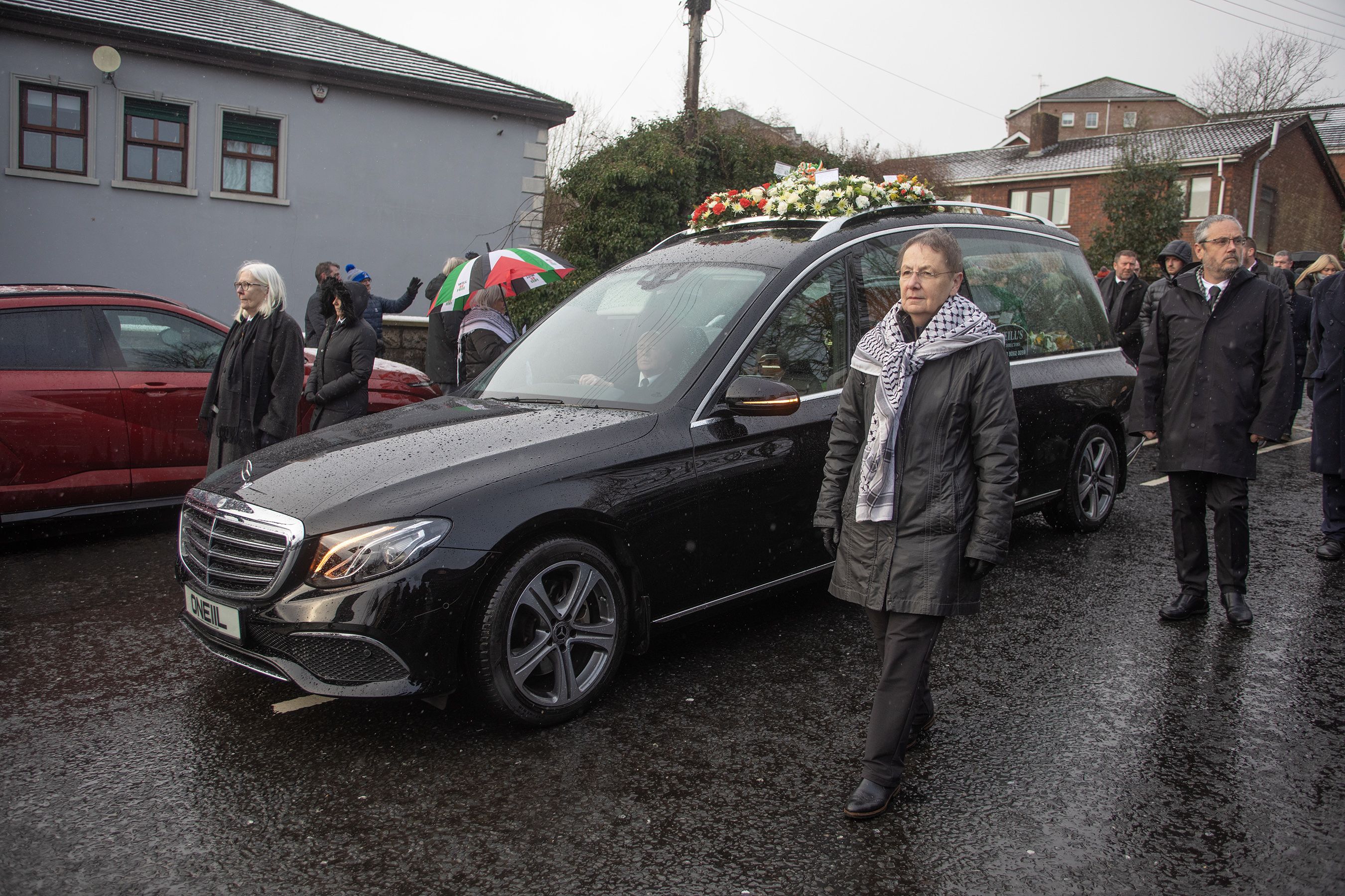 Bairbre de Brún and Liz Maskey walk alongside the hearse on the Suffolk Road this morning